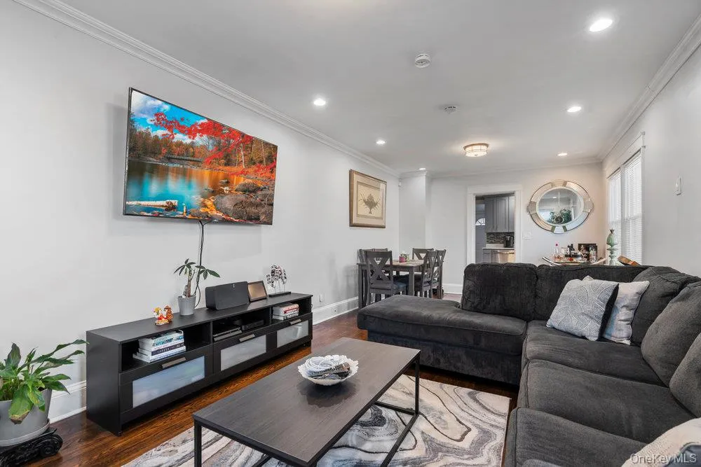 Living area featuring crown molding, wood finished floors, and recessed lighting Living area featuring crown molding, wood finished floors, and recessed lighting