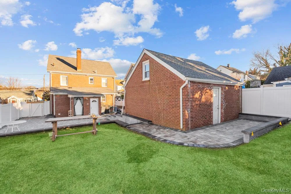 Back of house with brick siding, a fenced backyard, a patio area, and an outdoor structure Back of house with brick siding, a fenced backyard, a patio area, and an outdoor structure