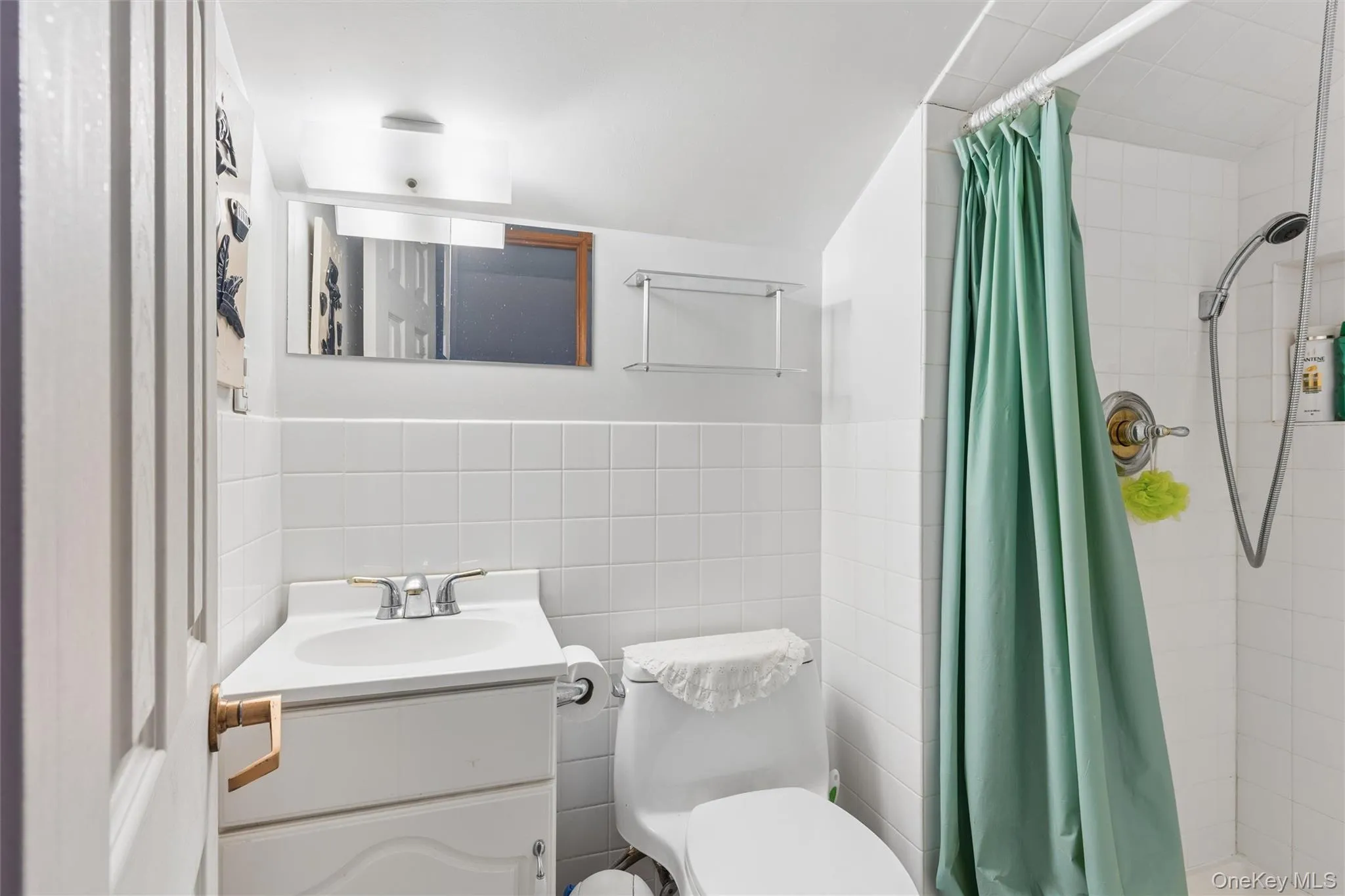 Attic Full bathroom with vanity, tile walls, a stall shower, and wainscoting Attic Full bathroom with vanity, tile walls, a stall shower, and wainscoting