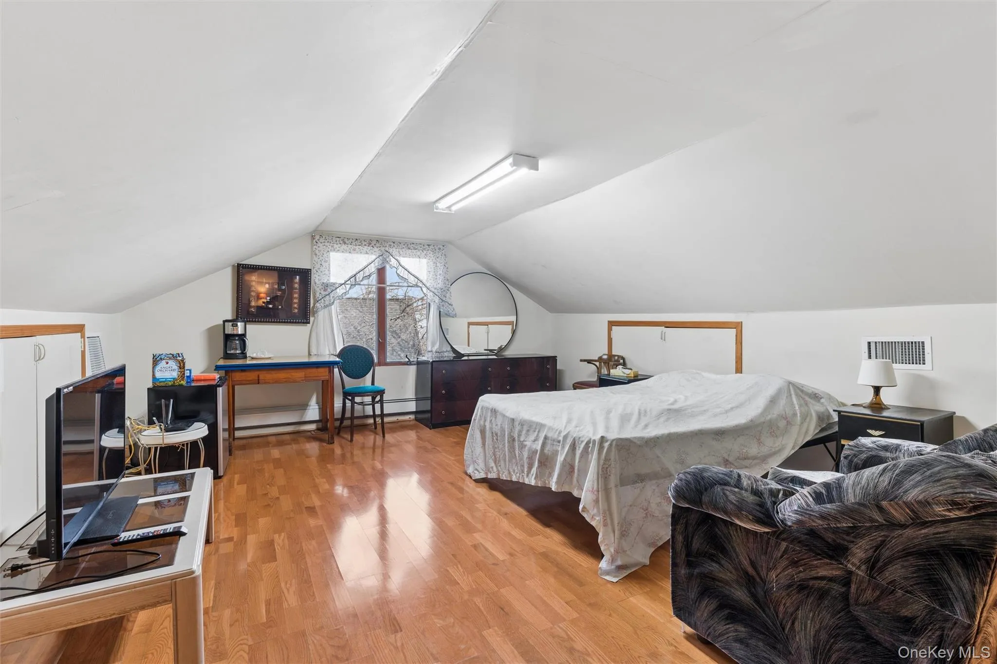 Guest Bedroom with light wood-style floors and baseboard heating Guest Bedroom with light wood-style floors and baseboard heating