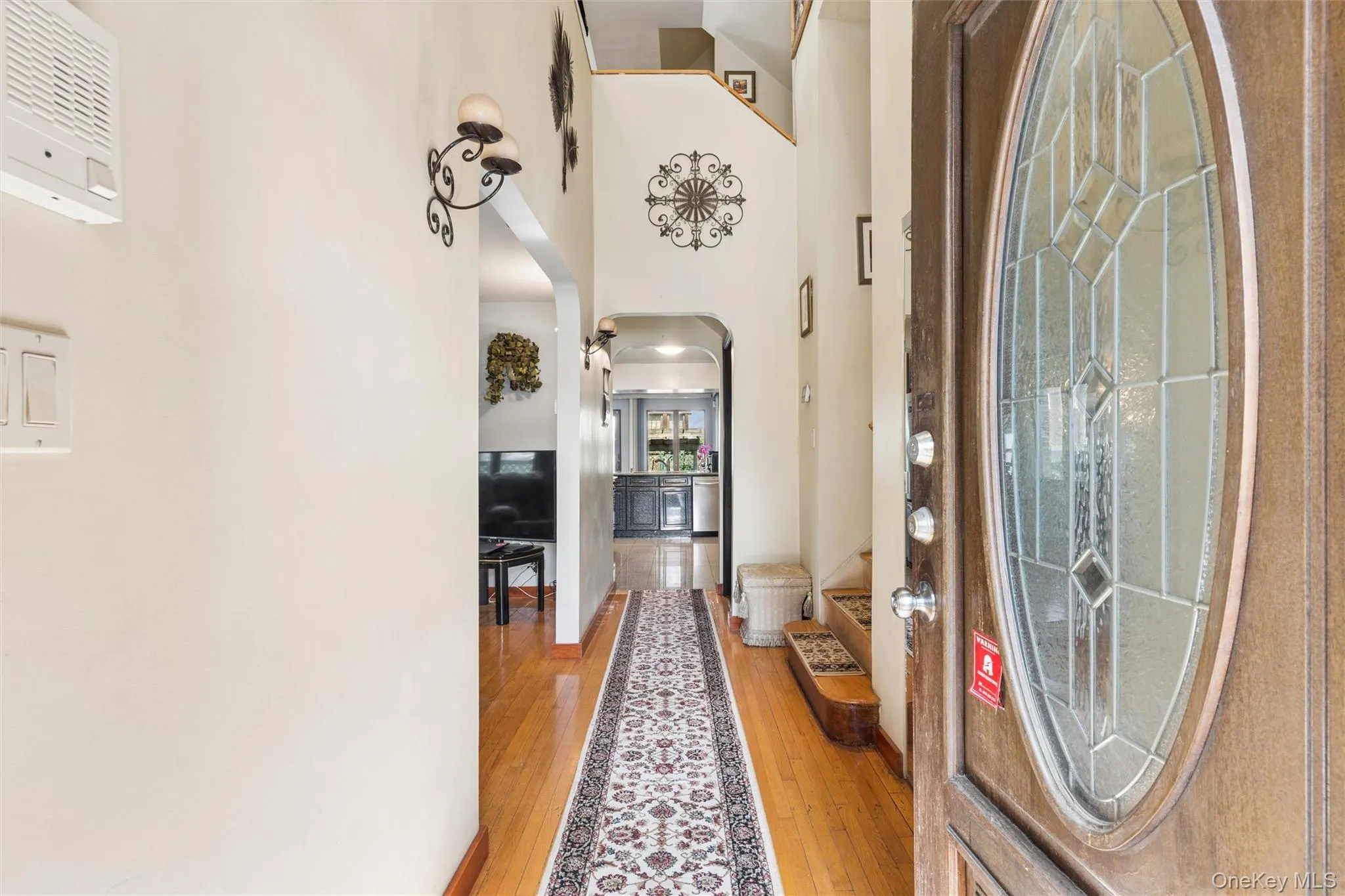 Foyer with arched walkways, a high ceiling, and light wood-type flooring Foyer with arched walkways, a high ceiling, and light wood-type flooring