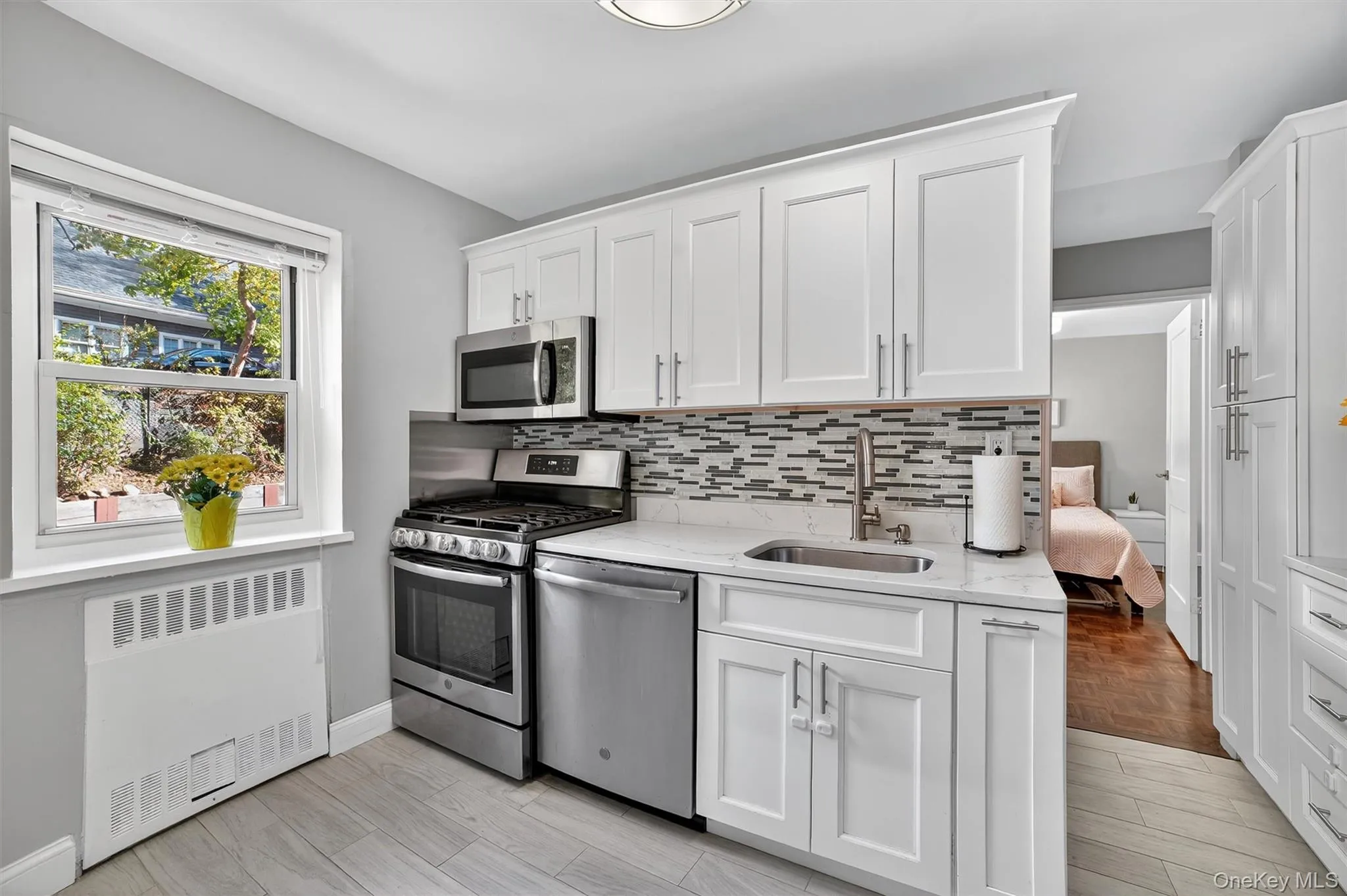 Kitchen with stainless-steel appliances, white cabinets, quartz countertops and tiled floor. Kitchen with stainless-steel appliances, white cabinets, quartz countertops and tiled floor.