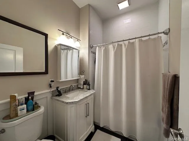 Full bath featuring vanity and a shower with shower curtain Full bath featuring vanity and a shower with shower curtain