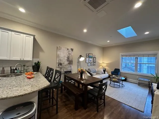 Dining area featuring crown molding, recessed lighting, dark wood-style floors, a skylight, and cooling unit Dining area featuring crown molding, recessed lighting, dark wood-style floors, a skylight, and cooling unit