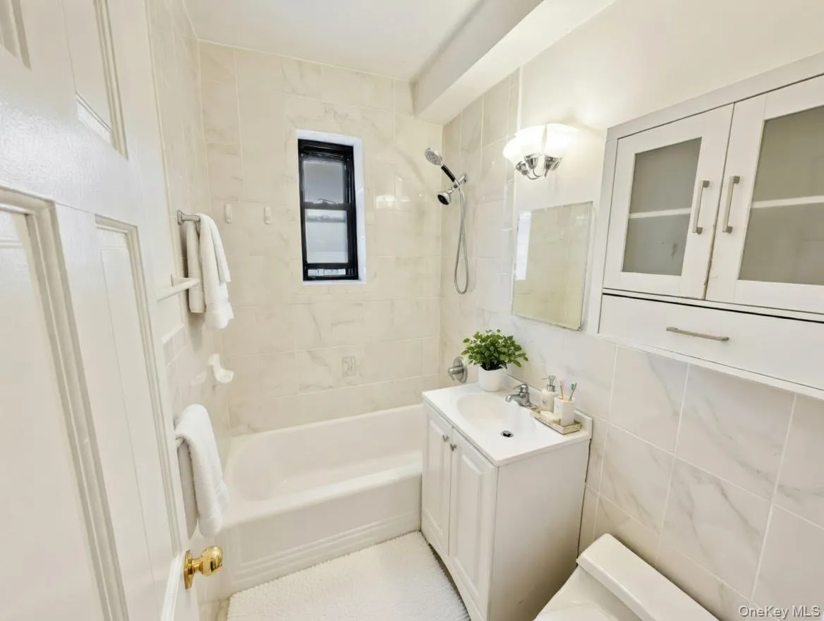 Full bath with vanity, tub / shower combination, and tile walls Full bath with vanity, tub / shower combination, and tile walls