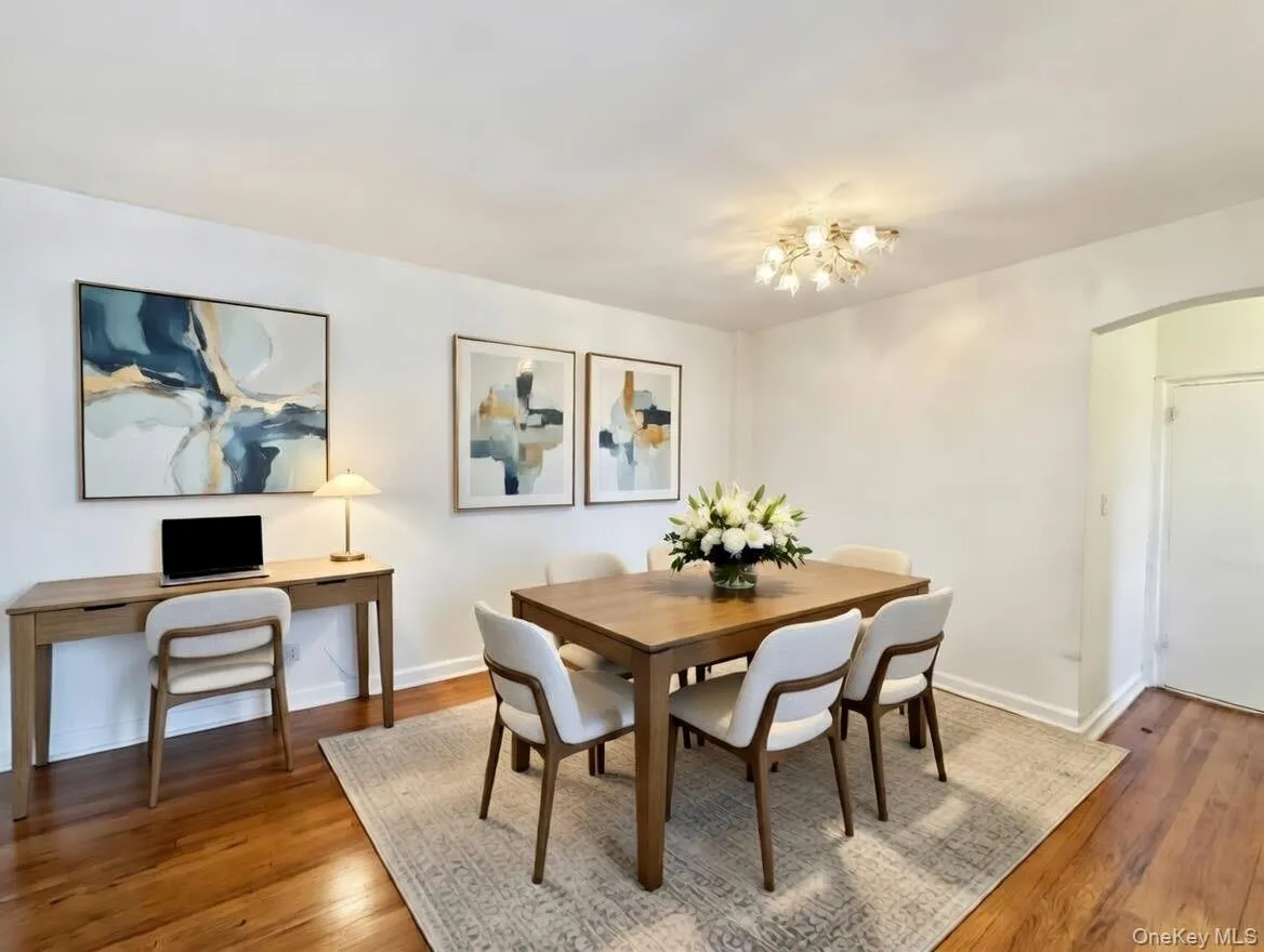 Dining room featuring arched walkways, hadrwood floors, and a chandelier Dining room featuring arched walkways, hadrwood floors, and a chandelier