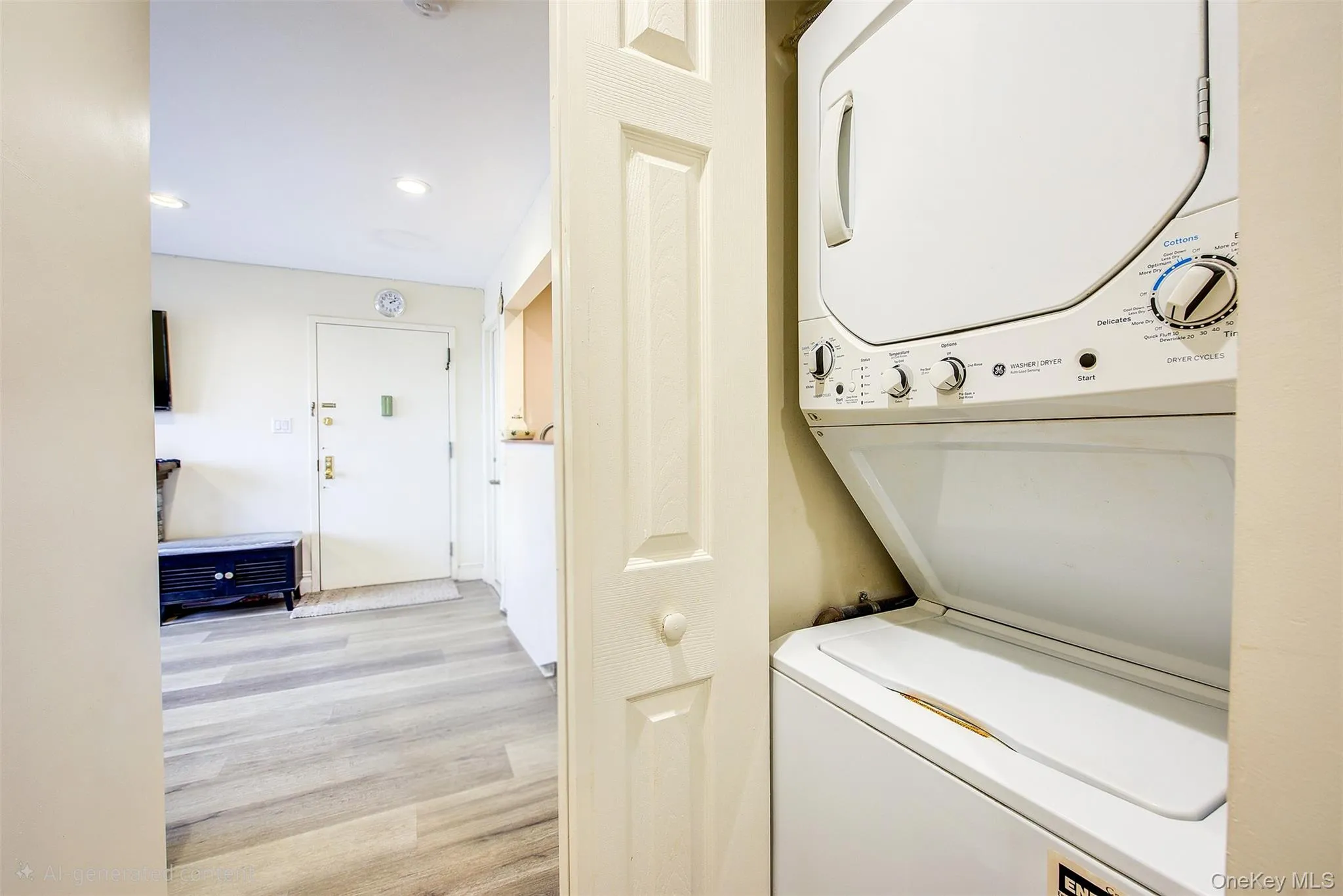 Laundry area with light wood-type flooring, recessed lighting, and stacked washing machine and dryer Laundry area with light wood-type flooring, recessed lighting, and stacked washing machine and dryer