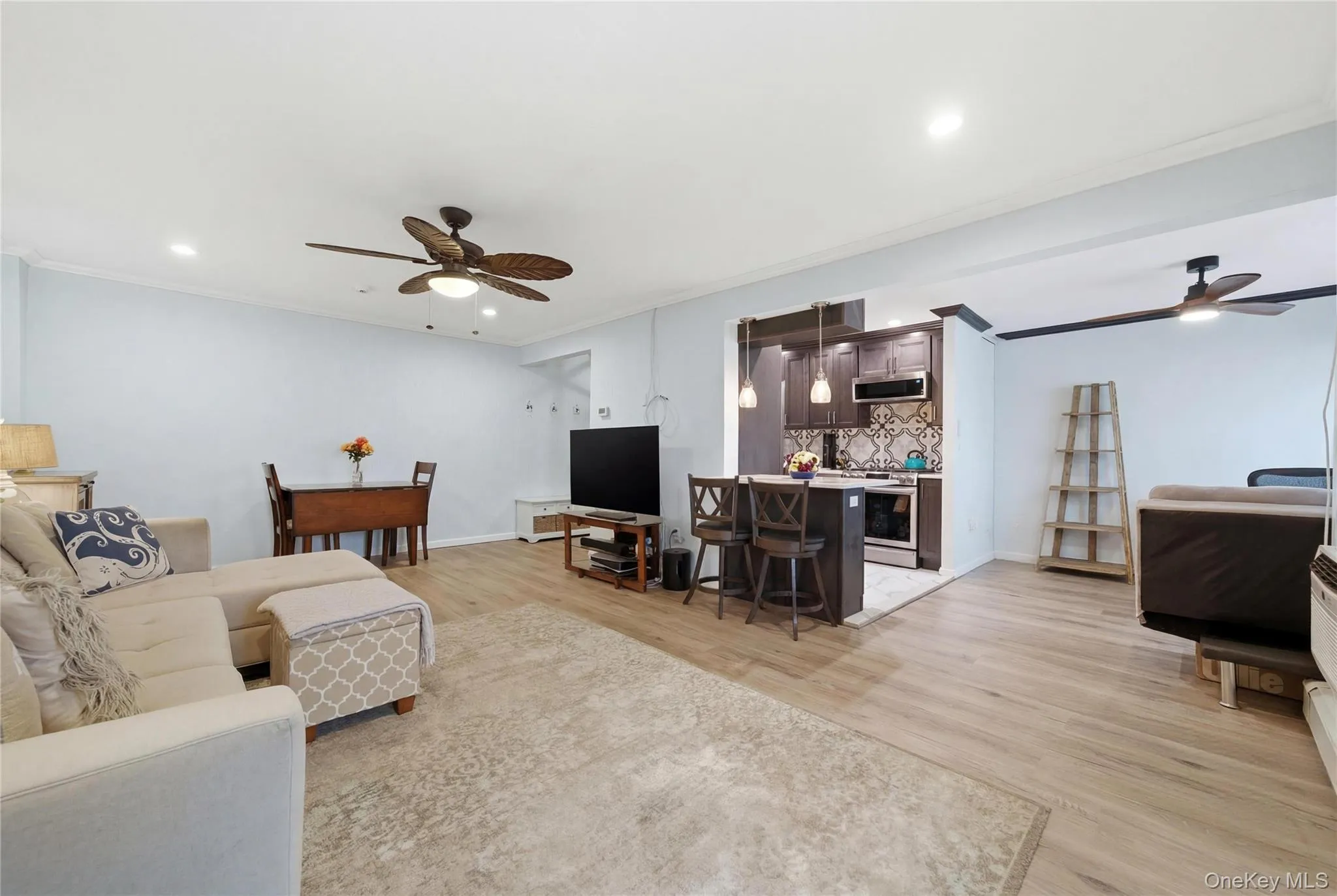 Living room featuring ceiling fan, crown molding, light wood-type flooring, and recessed lighting Living room featuring ceiling fan, crown molding, light wood-type flooring, and recessed lighting