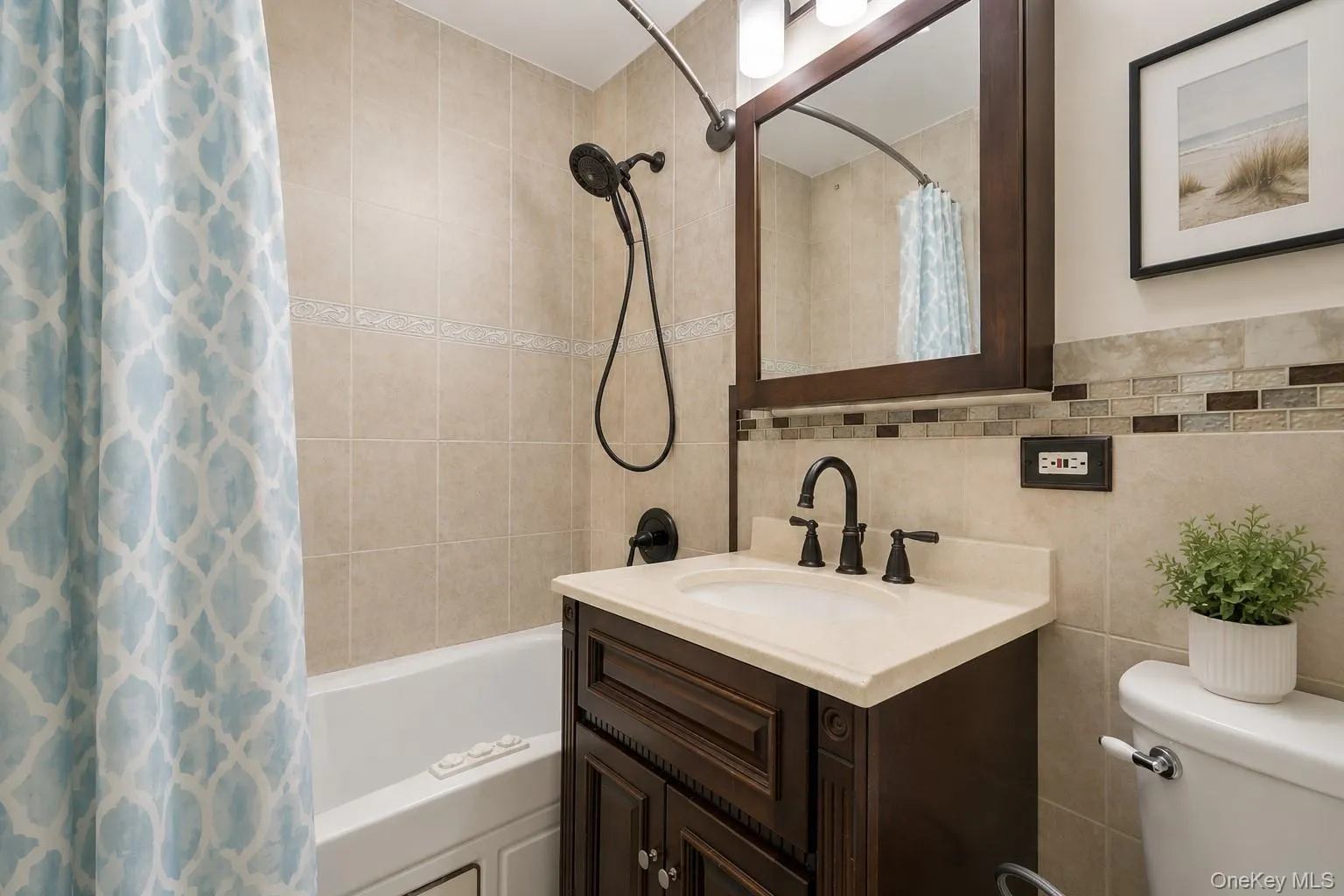 Bathroom vanity featuring a light-toned countertop with an integrated sink, dark wood-finish cabinetry, and oil-rubbed bronze fixtures Bathroom vanity featuring a light-toned countertop with an integrated sink, dark wood-finish cabinetry, and oil-rubbed bronze fixtures