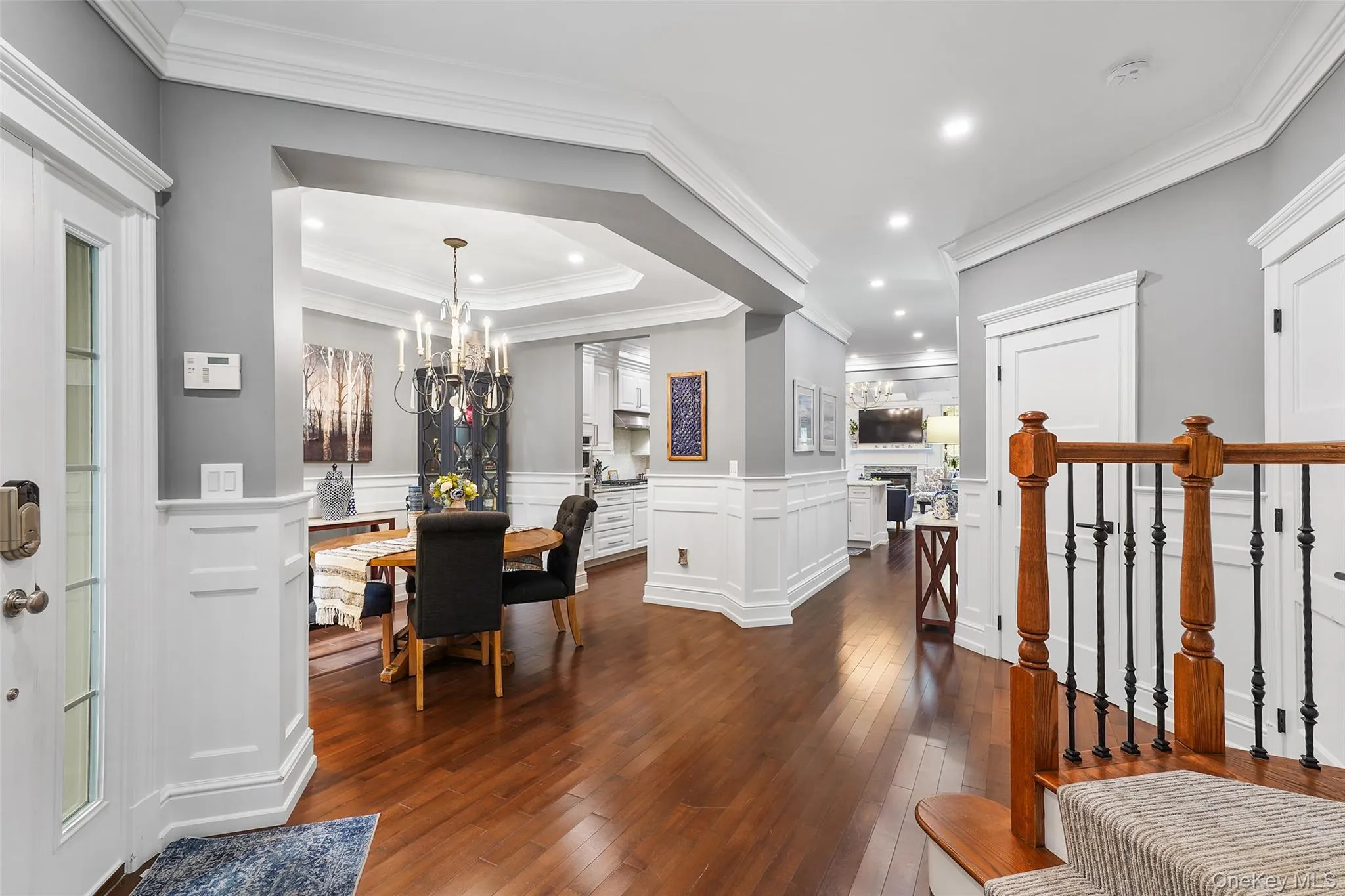 Dining area featuring dark wood-type flooring, a chandelier, recessed lighting, a fireplace, and ornamental molding Dining area featuring dark wood-type flooring, a chandelier, recessed lighting, a fireplace, and ornamental molding