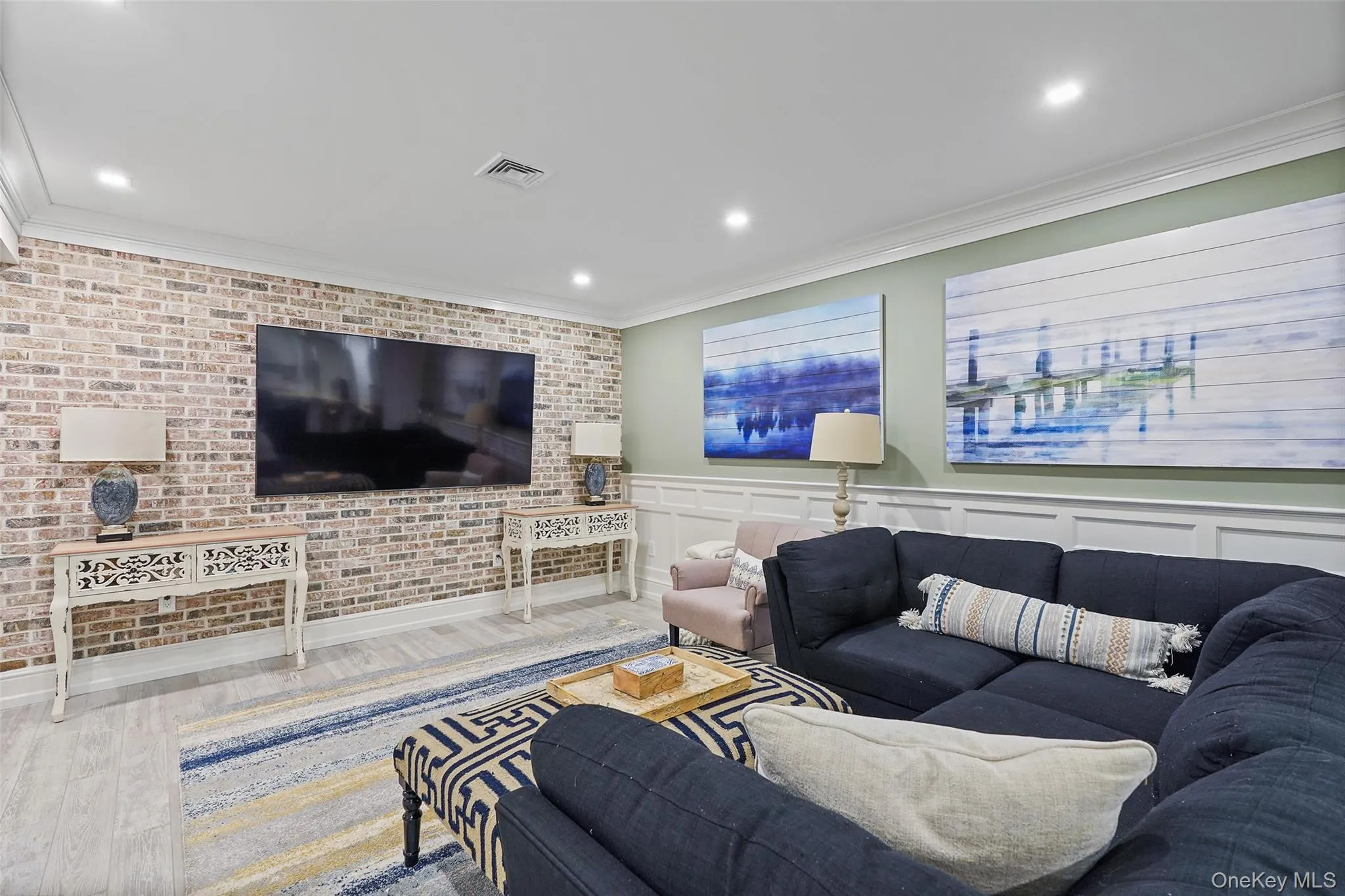Living area with crown molding, wood finished floors, recessed lighting, wainscoting, and brick wall Living area with crown molding, wood finished floors, recessed lighting, wainscoting, and brick wall