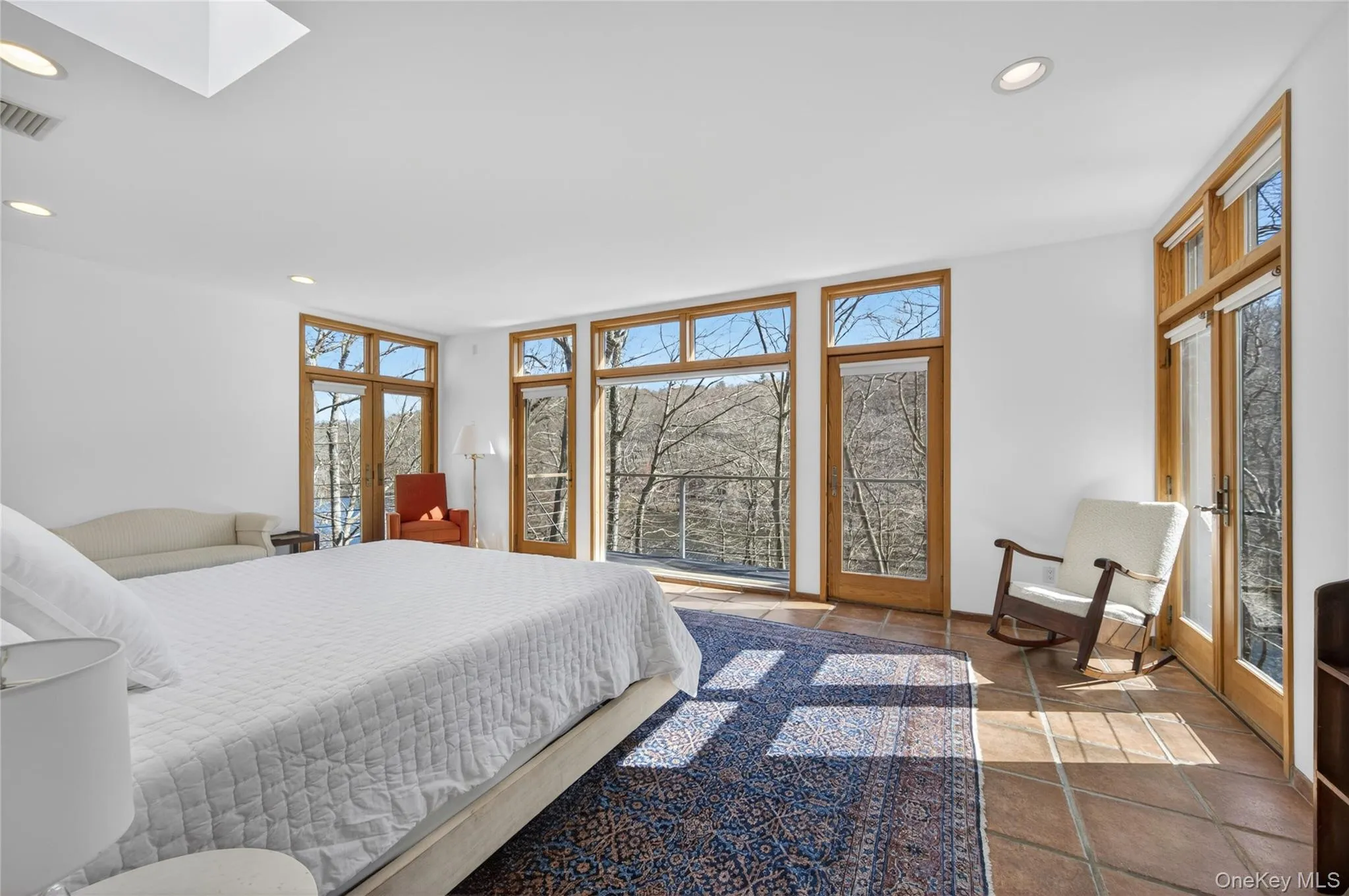 Spacious room featuring multiple large windows and glass-paneled doors with wood frames Spacious room featuring multiple large windows and glass-paneled doors with wood frames