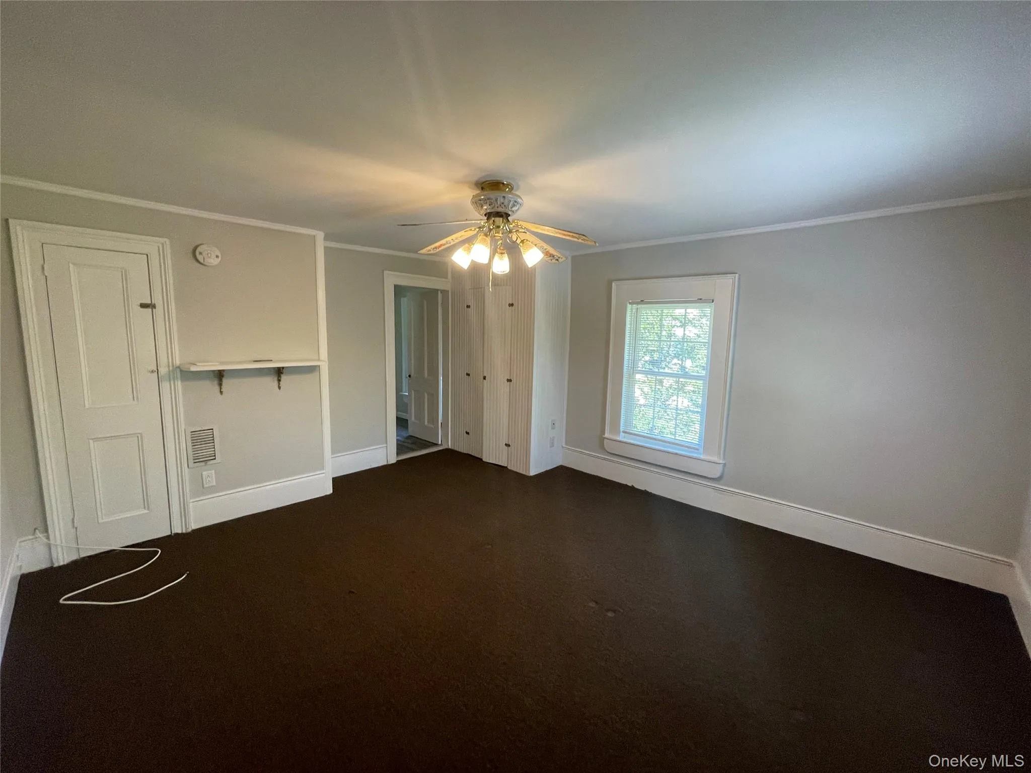 Unfurnished bedroom with ornamental molding and a ceiling fan Unfurnished bedroom with ornamental molding and a ceiling fan