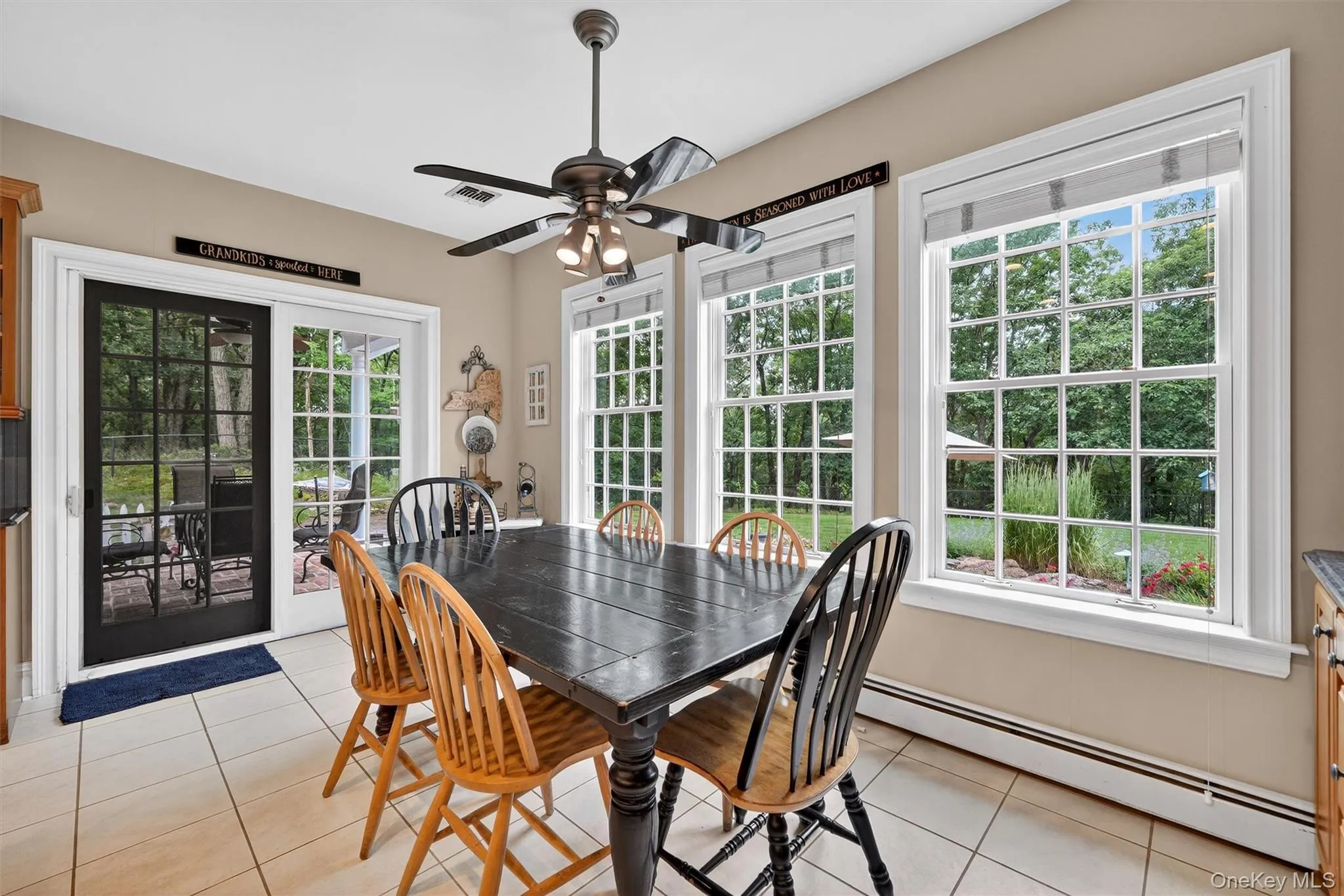 Dining area with baseboard heating, light tile patterned floors, and ceiling fan Dining area with baseboard heating, light tile patterned floors, and ceiling fan