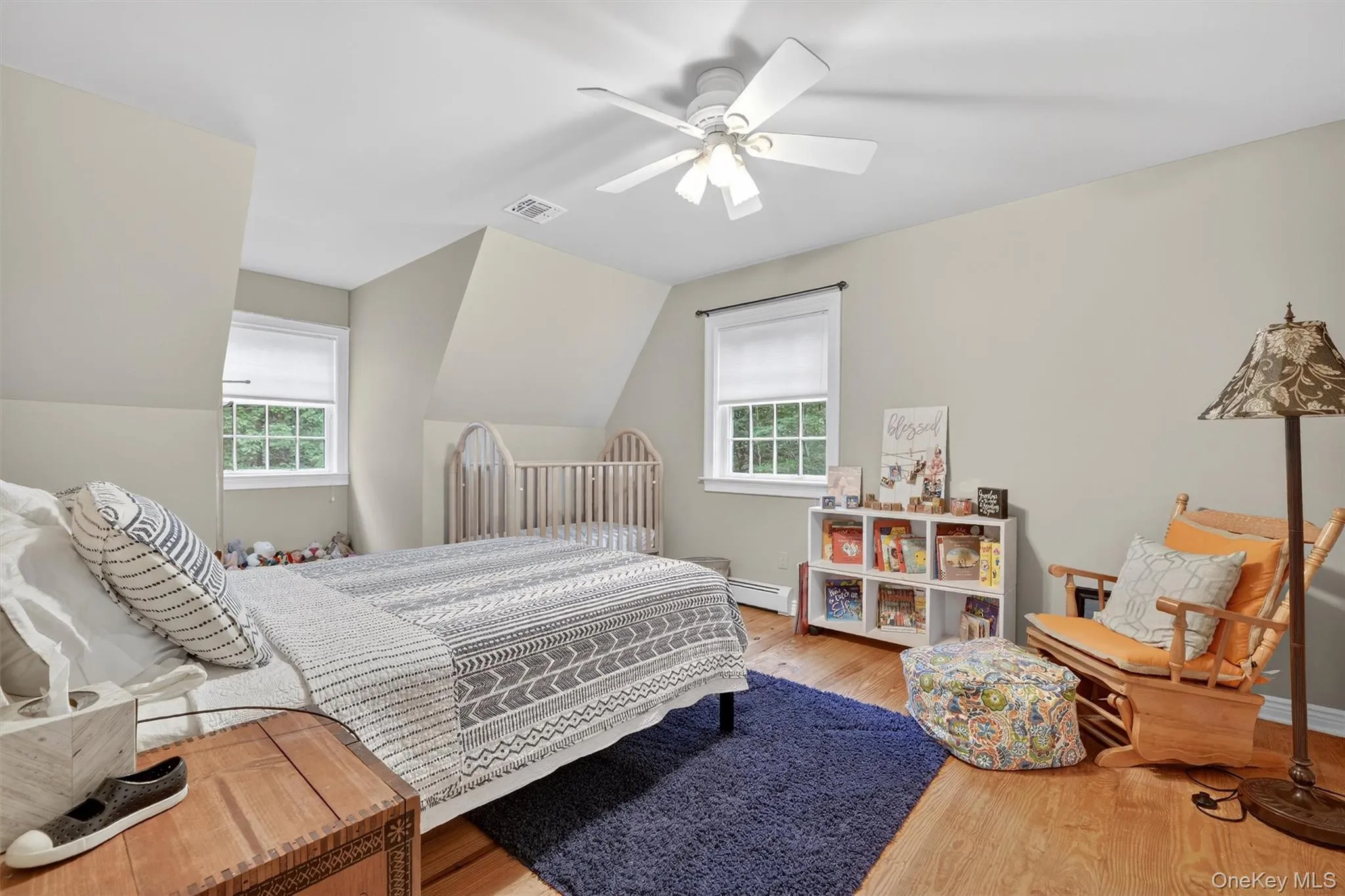Bedroom featuring wood finished floors, a baseboard heating unit, vaulted ceiling, and ceiling fan Bedroom featuring wood finished floors, a baseboard heating unit, vaulted ceiling, and ceiling fan