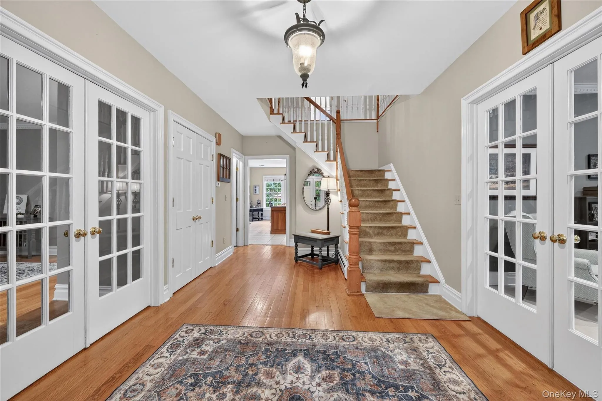 Foyer with french doors, wood finished floors, and stairway Foyer with french doors, wood finished floors, and stairway