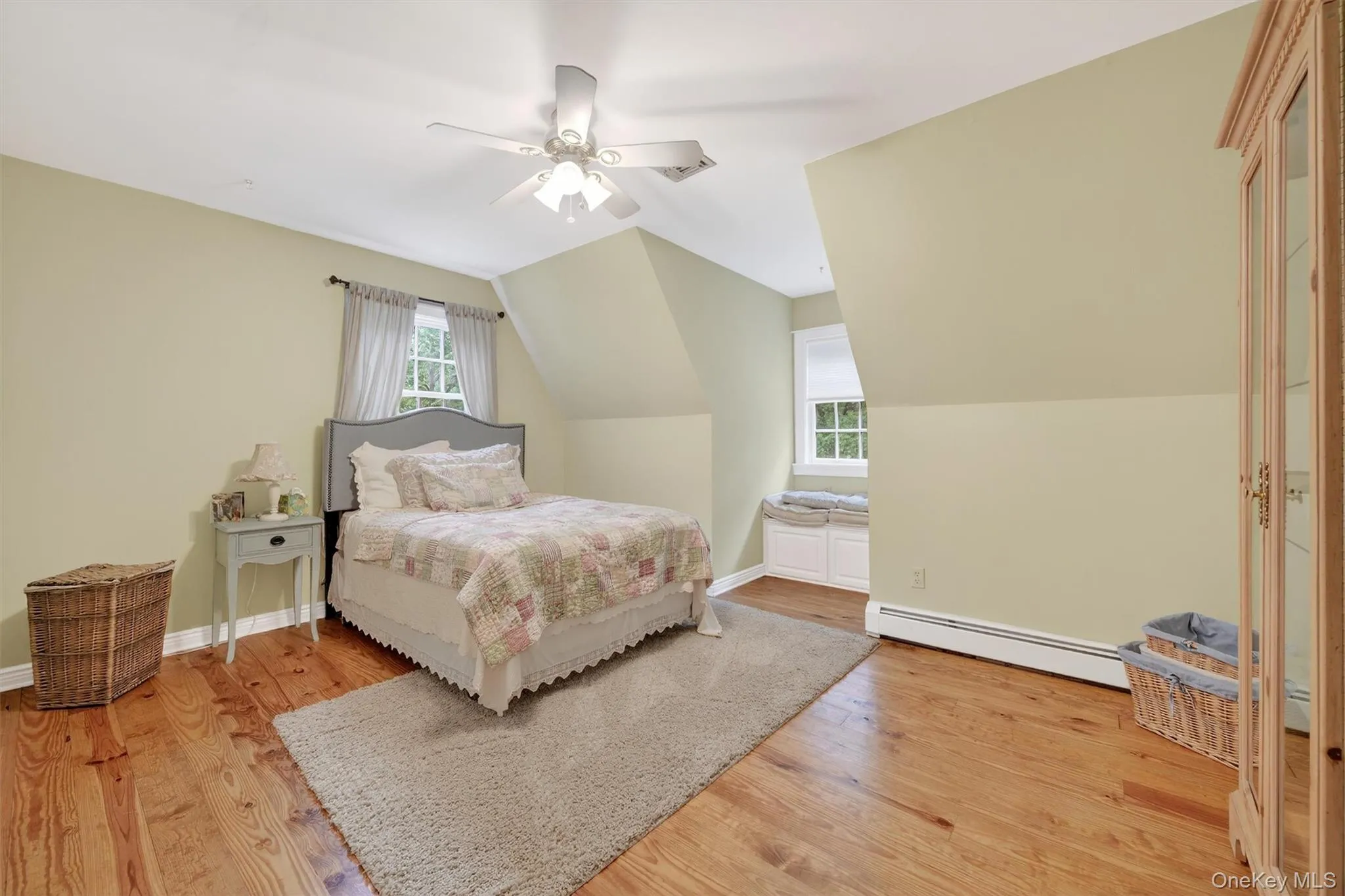 Bedroom with baseboard heating, light wood-style floors, a ceiling fan, and lofted ceiling Bedroom with baseboard heating, light wood-style floors, a ceiling fan, and lofted ceiling