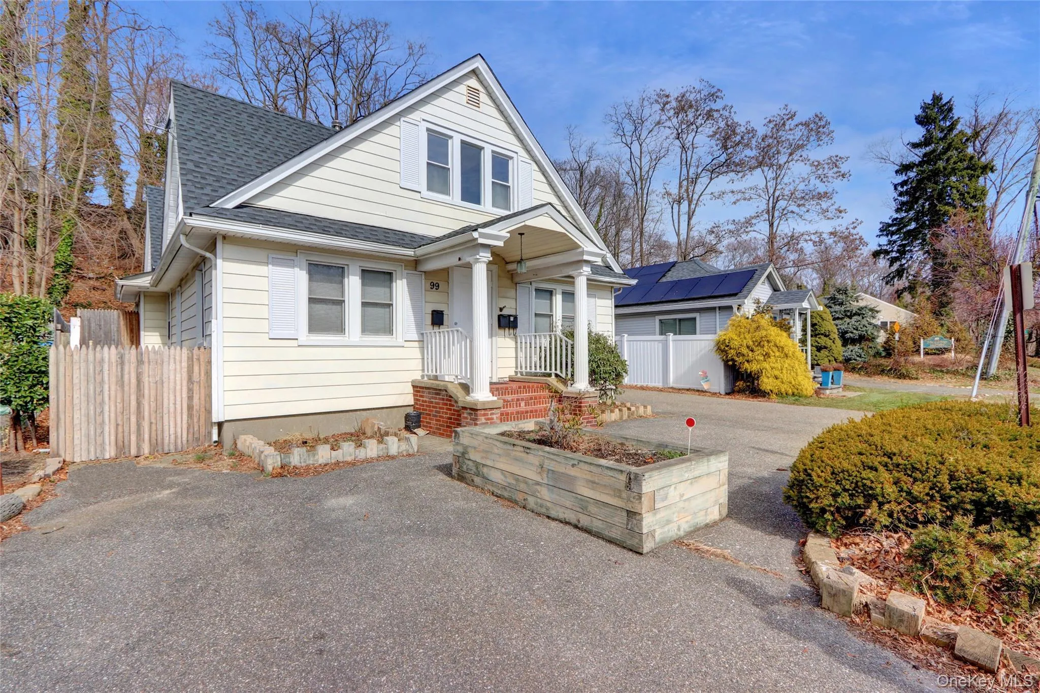View of front facade featuring driveway, roof with shingles, and fence View of front facade featuring driveway, roof with shingles, and fence