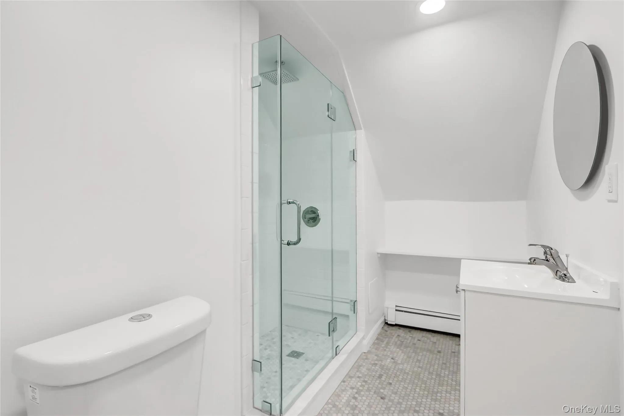 Bathroom featuring toilet, a shower stall, a baseboard radiator, lofted ceiling, and vanity Bathroom featuring toilet, a shower stall, a baseboard radiator, lofted ceiling, and vanity
