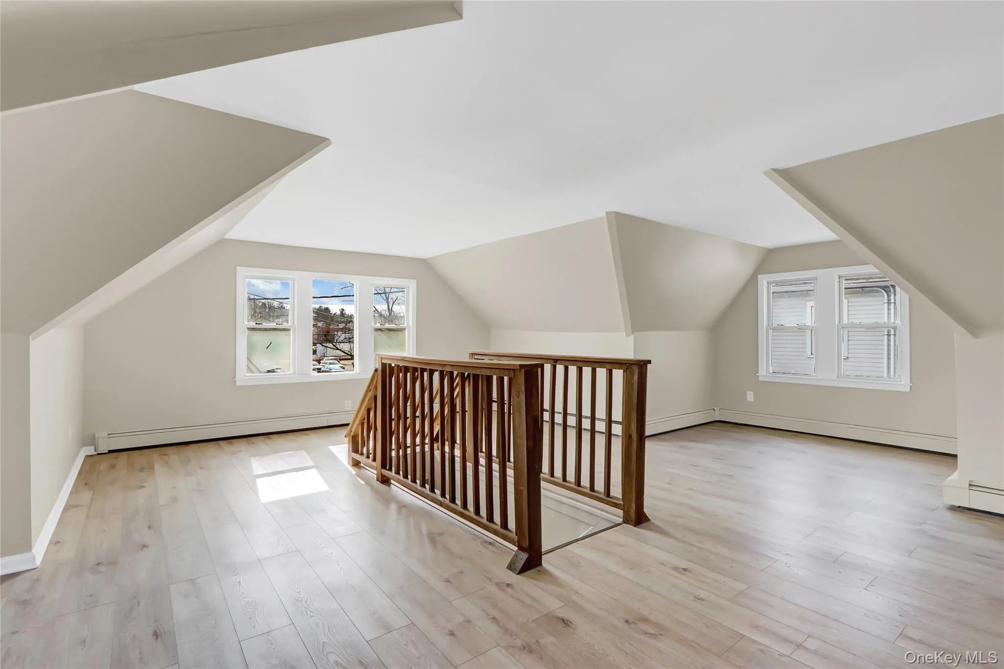 Bonus room with a baseboard heating unit, lofted ceiling, and light wood-style flooring Bonus room with a baseboard heating unit, lofted ceiling, and light wood-style flooring