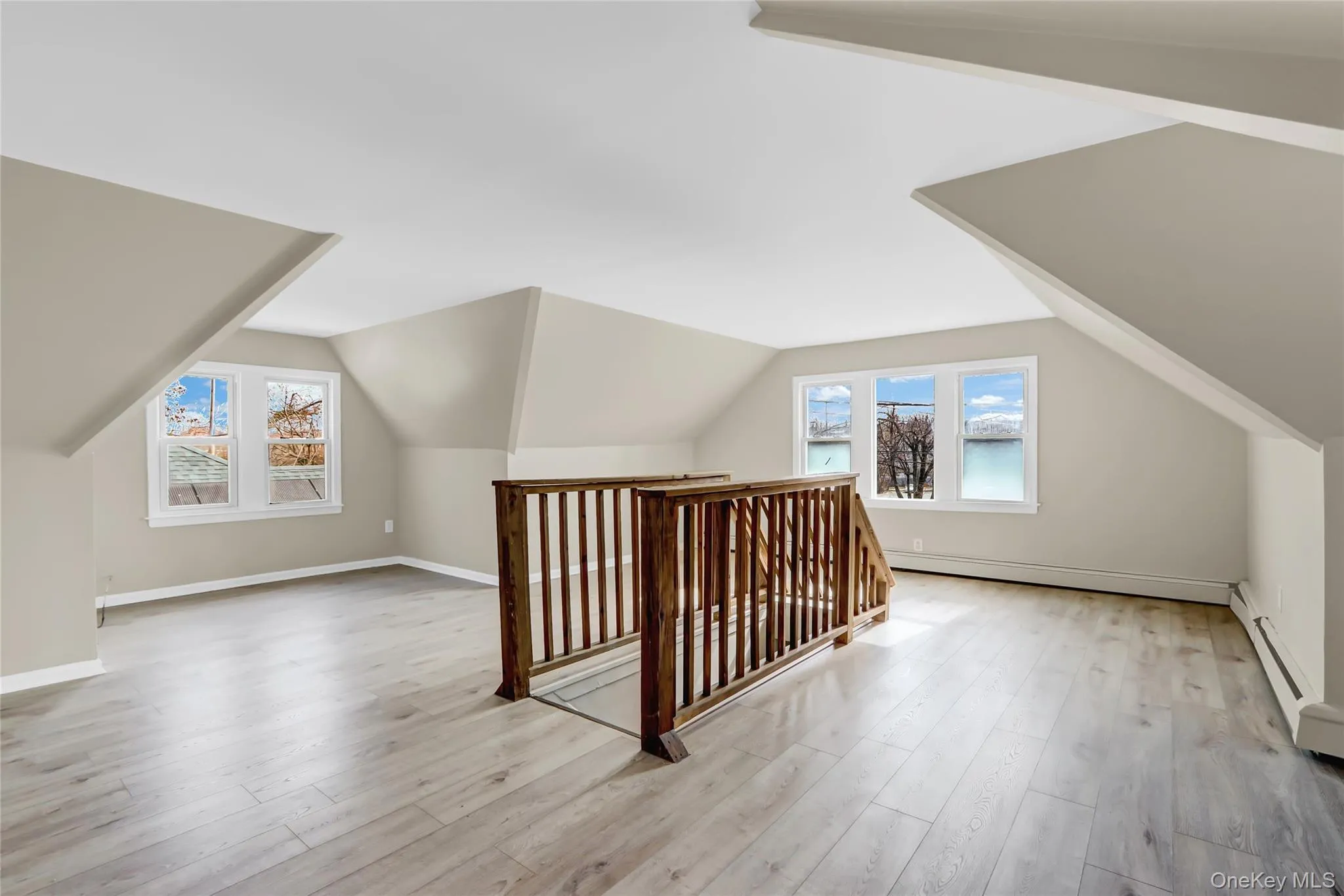 Bonus room featuring light wood-type flooring, baseboards, and a healthy amount of sunlight Bonus room featuring light wood-type flooring, baseboards, and a healthy amount of sunlight