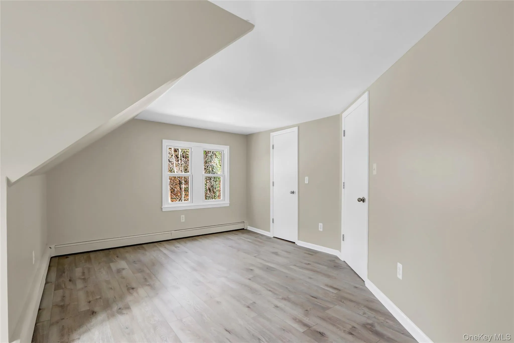 Bonus room featuring light wood-style flooring, baseboards, and baseboard heating Bonus room featuring light wood-style flooring, baseboards, and baseboard heating