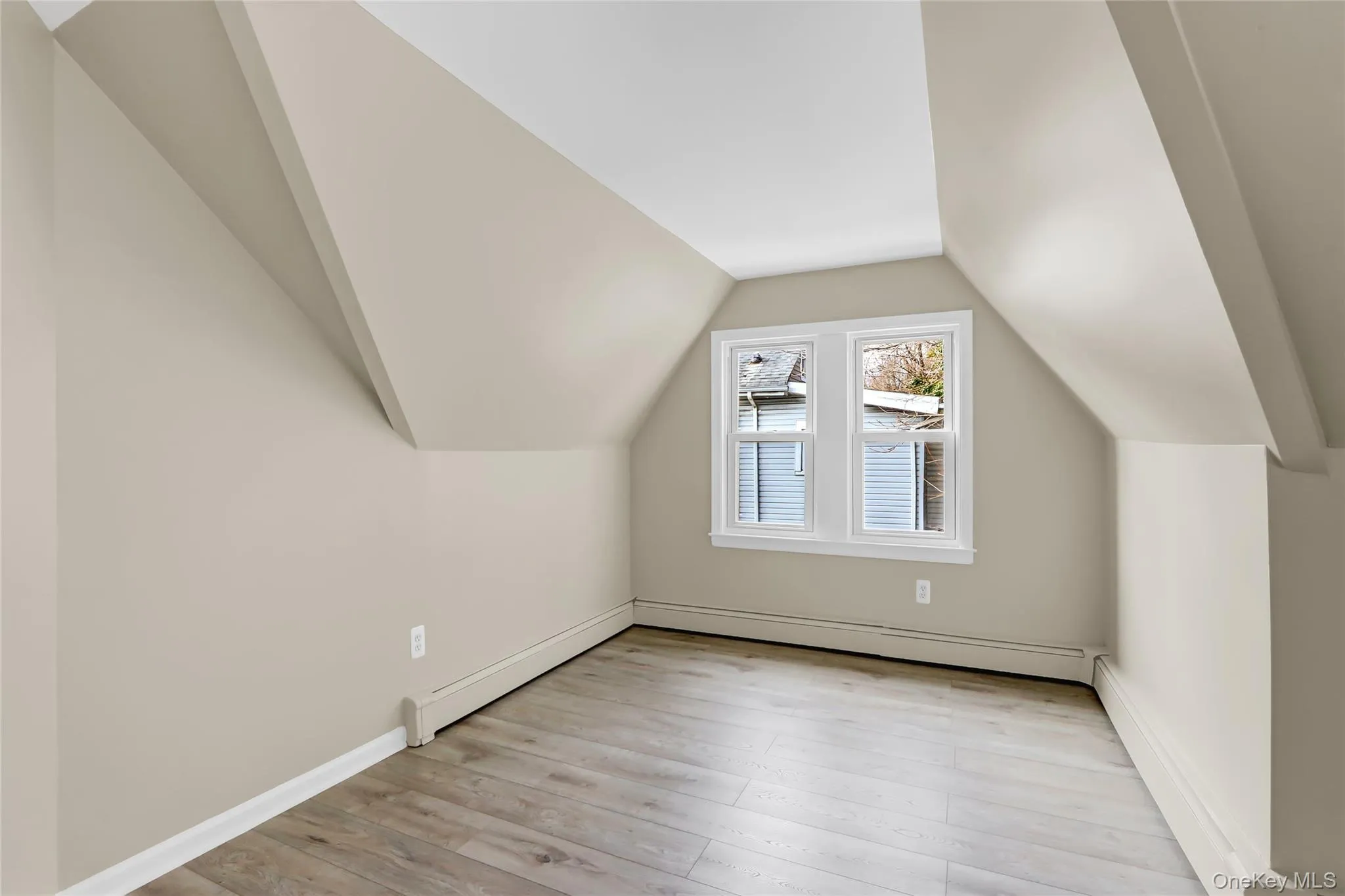 Additional living space with baseboards, a baseboard heating unit, light wood-style floors, and vaulted ceiling Additional living space with baseboards, a baseboard heating unit, light wood-style floors, and vaulted ceiling