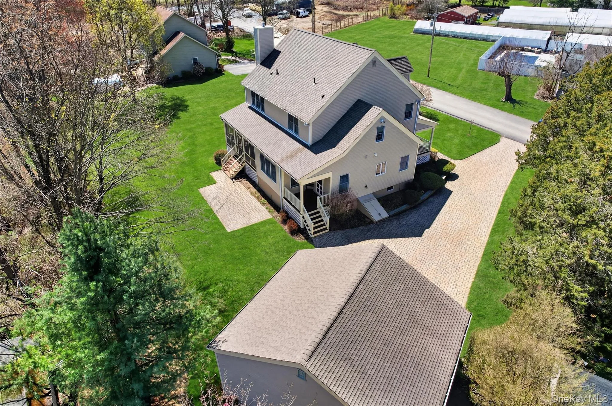 An aerial perspective showcases the property’s layout, highlighting the home, detached garage, and beautifully maintained grounds. An aerial perspective showcases the property’s layout, highlighting the home, detached garage, and beautifully maintained grounds.