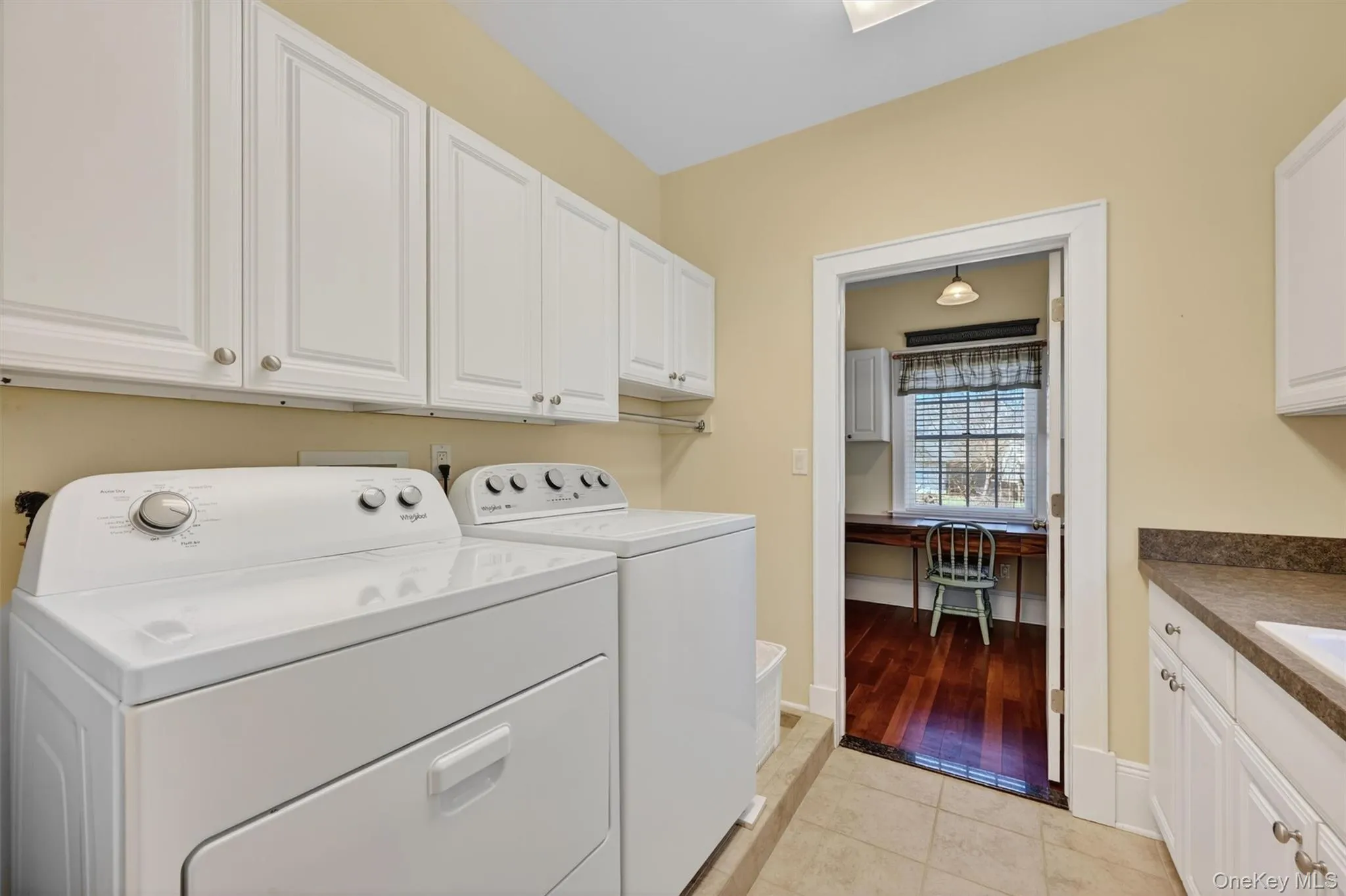 A bright and functional laundry room with ample cabinetry and workspace, conveniently located on the main level for everyday ease. A bright and functional laundry room with ample cabinetry and workspace, conveniently located on the main level for everyday ease.