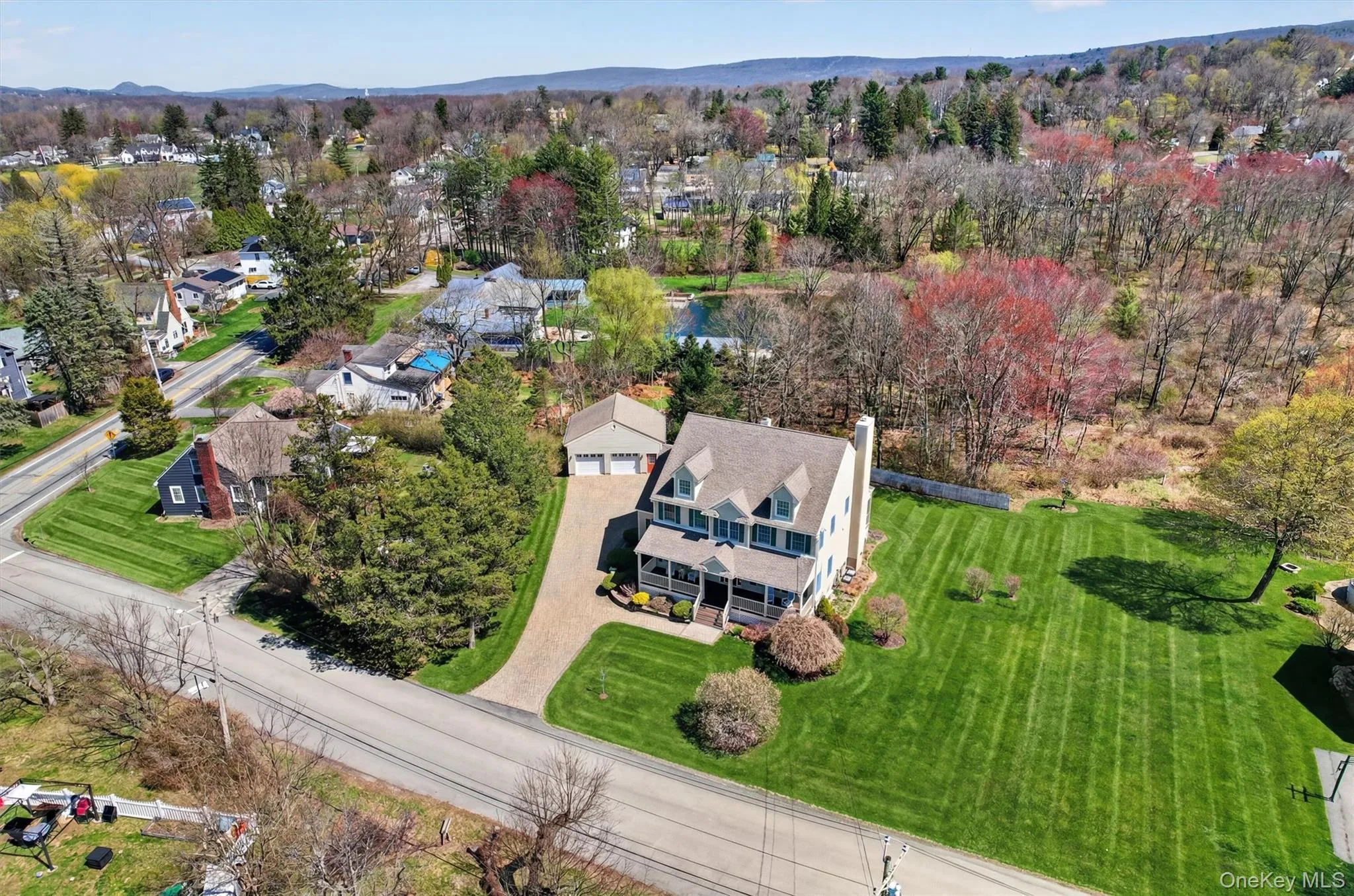 An aerial view showcasing the home’s generous setting, expansive lawn, and detached two-car garage, offering both privacy and space to enjoy the outdoors. An aerial view showcasing the home’s generous setting, expansive lawn, and detached two-car garage, offering both privacy and space to enjoy the outdoors.