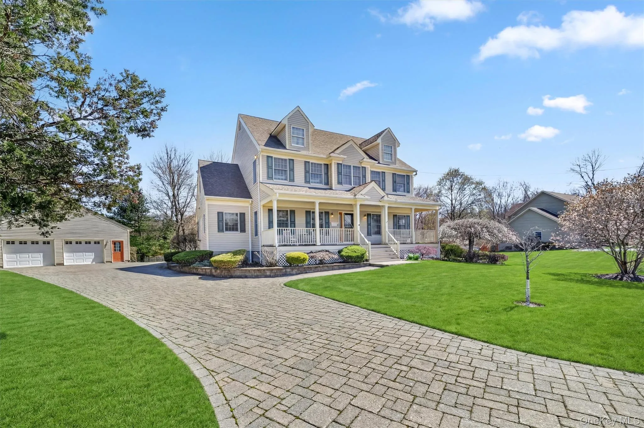 Timeless curb appeal meets thoughtful design, highlighted by a sweeping paver driveway, lush landscaping, and a charming wraparound front porch. The paver driveway adds to the home’s curb appeal and leads to a spacious two-car detached garage, offering both convenience and additional storage above. Timeless curb appeal meets thoughtful design, highlighted by a sweeping paver driveway, lush landscaping, and a charming wraparound front porch. The paver driveway adds to the home’s curb appeal and leads to a spacious two-car detached garage, offering both convenience and additional storage above.
