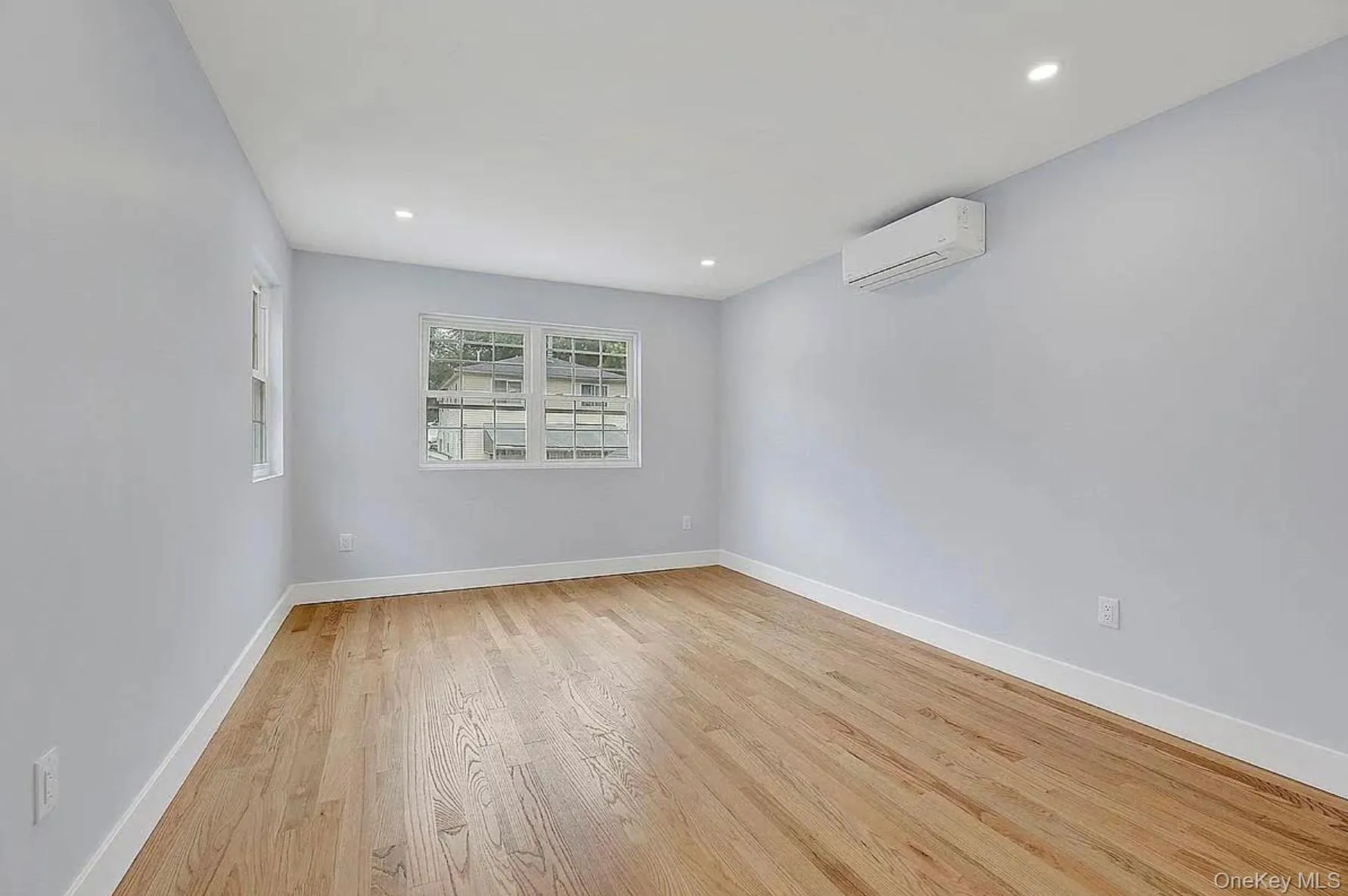 Spare room featuring an AC wall unit, light wood-style floors, baseboards, and recessed lighting Spare room featuring an AC wall unit, light wood-style floors, baseboards, and recessed lighting