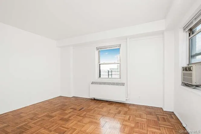 2nd bedroom with plenty of natural light, radiator, and cooling unit 2nd bedroom with plenty of natural light, radiator, and cooling unit