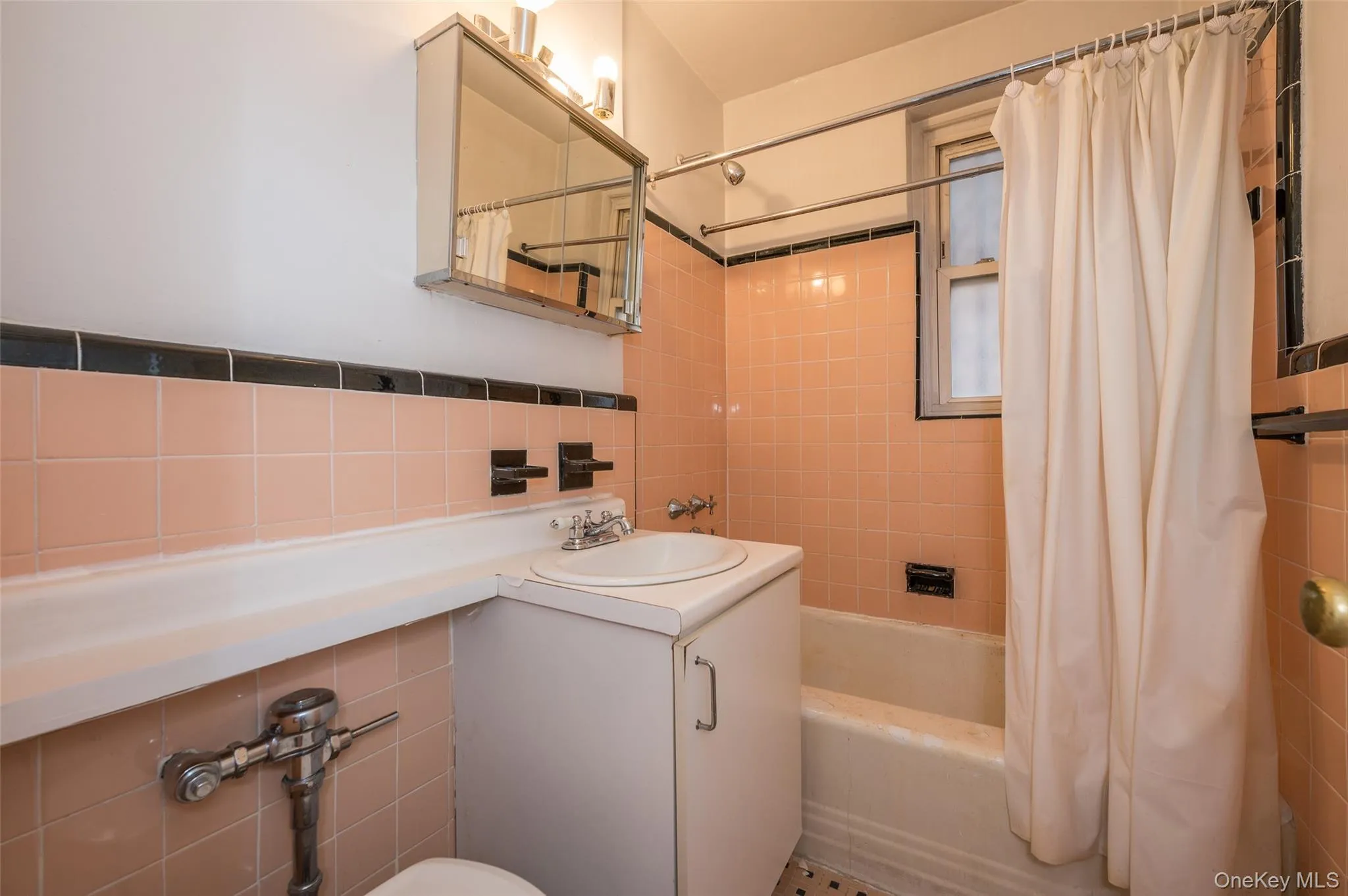 Full bath featuring vanity, shower / bathtub combination with curtain, and tile walls Full bath featuring vanity, shower / bathtub combination with curtain, and tile walls