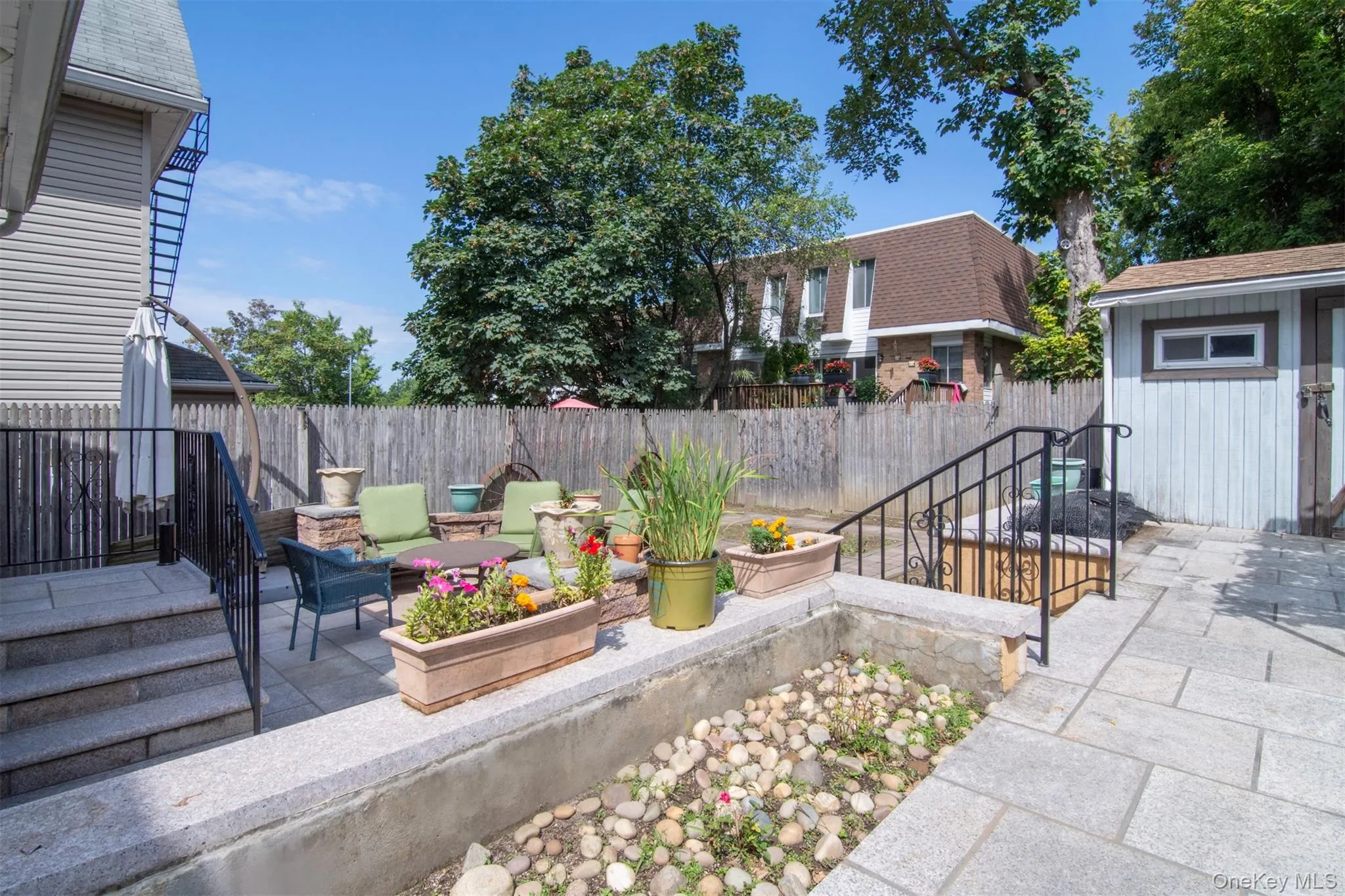 Fenced backyard with upper and lower patios. Shed on upper level Fenced backyard with upper and lower patios. Shed on upper level