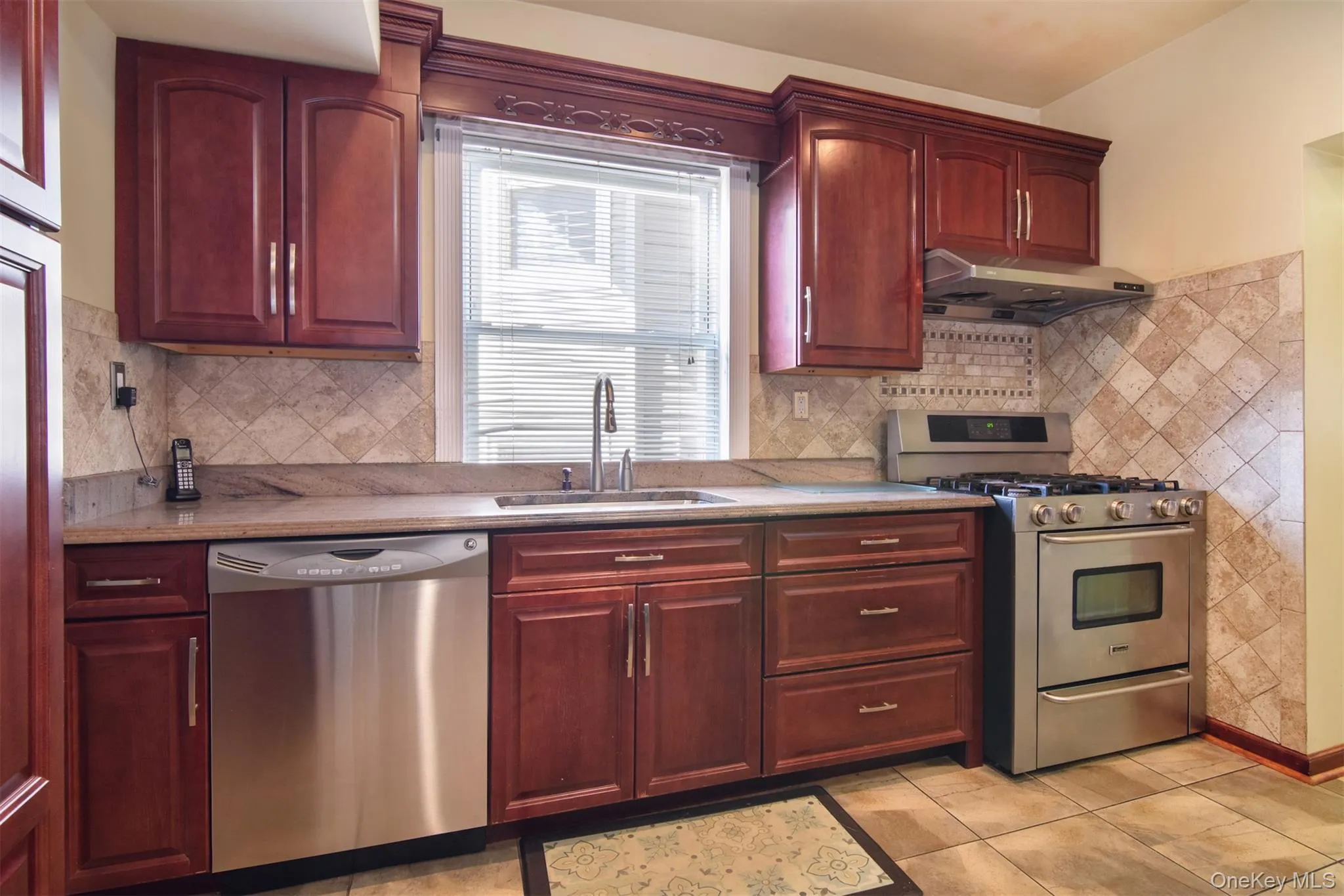 Kitchen featuring stainless steel appliances, exquisite Cherry cabinets, and tiled floor Kitchen featuring stainless steel appliances, exquisite Cherry cabinets, and tiled floor