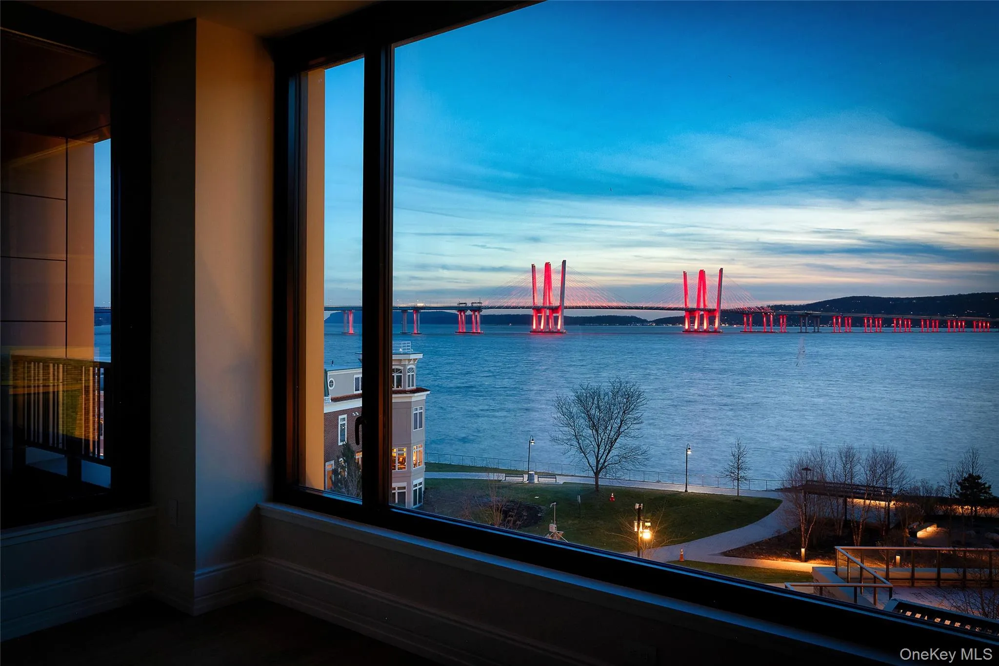 Twilight view from the living room showcasing the Hudson River and bridge Twilight view from the living room showcasing the Hudson River and bridge