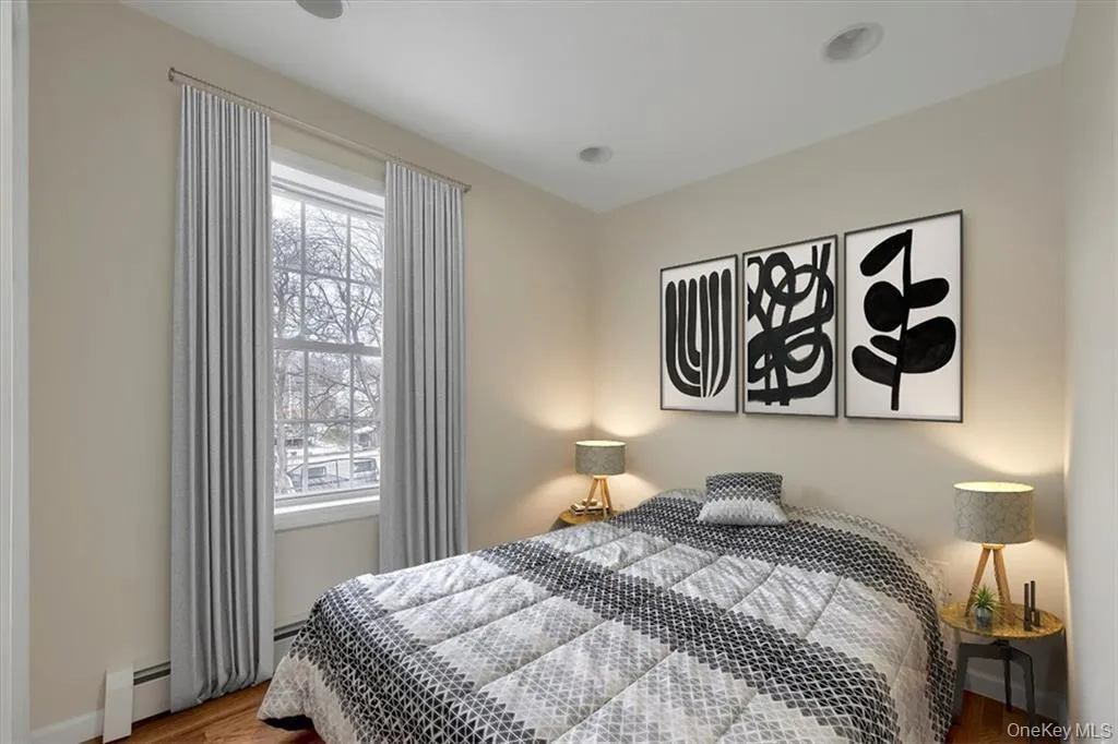 Virtually Staged, Cozy bedroom featuring hardwood floors, recessed lighting, and a large window for natural light. Virtually Staged, Cozy bedroom featuring hardwood floors, recessed lighting, and a large window for natural light.