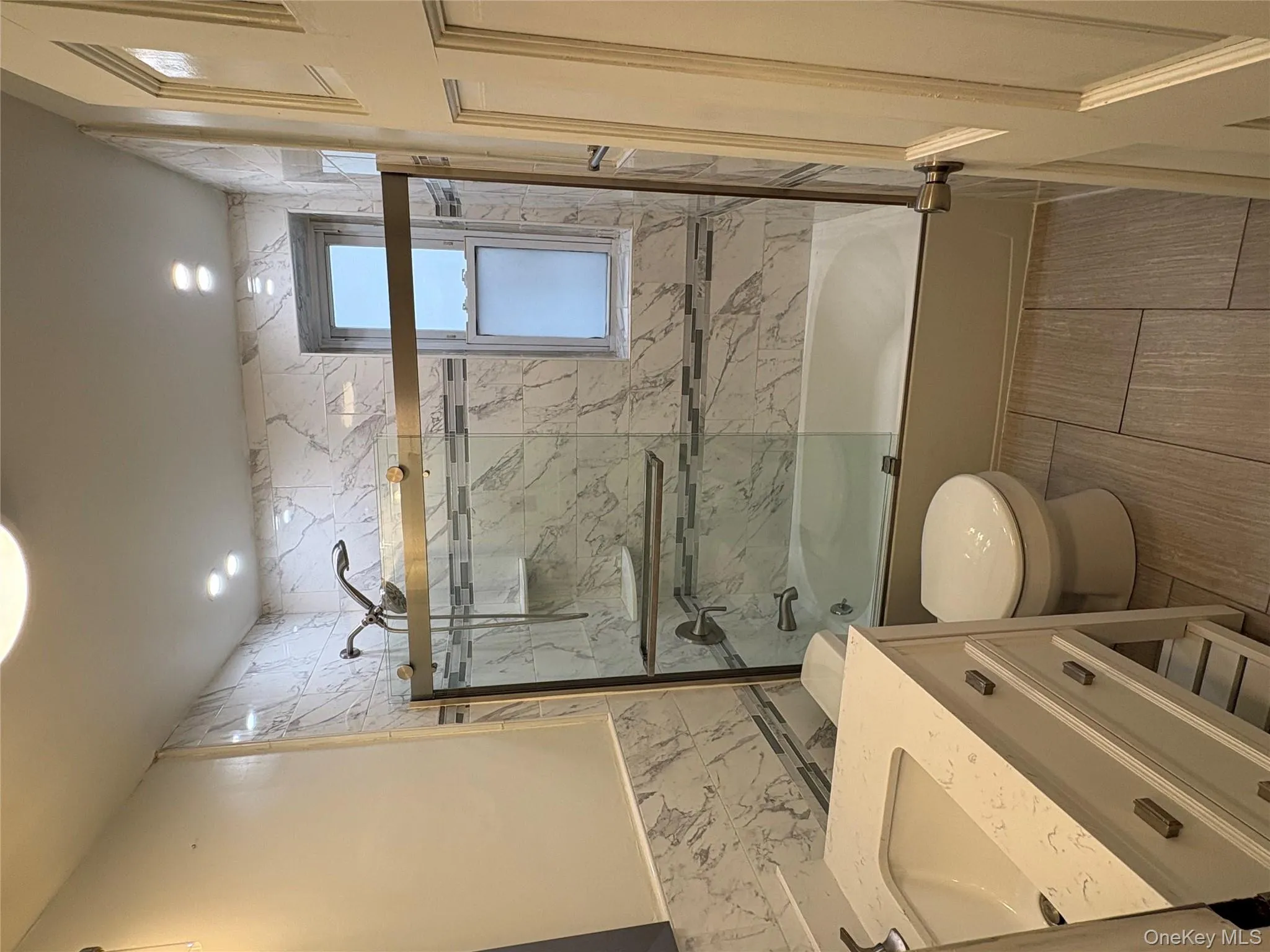 Full bathroom featuring vanity, bath / shower combo with glass door, and tile walls Full bathroom featuring vanity, bath / shower combo with glass door, and tile walls