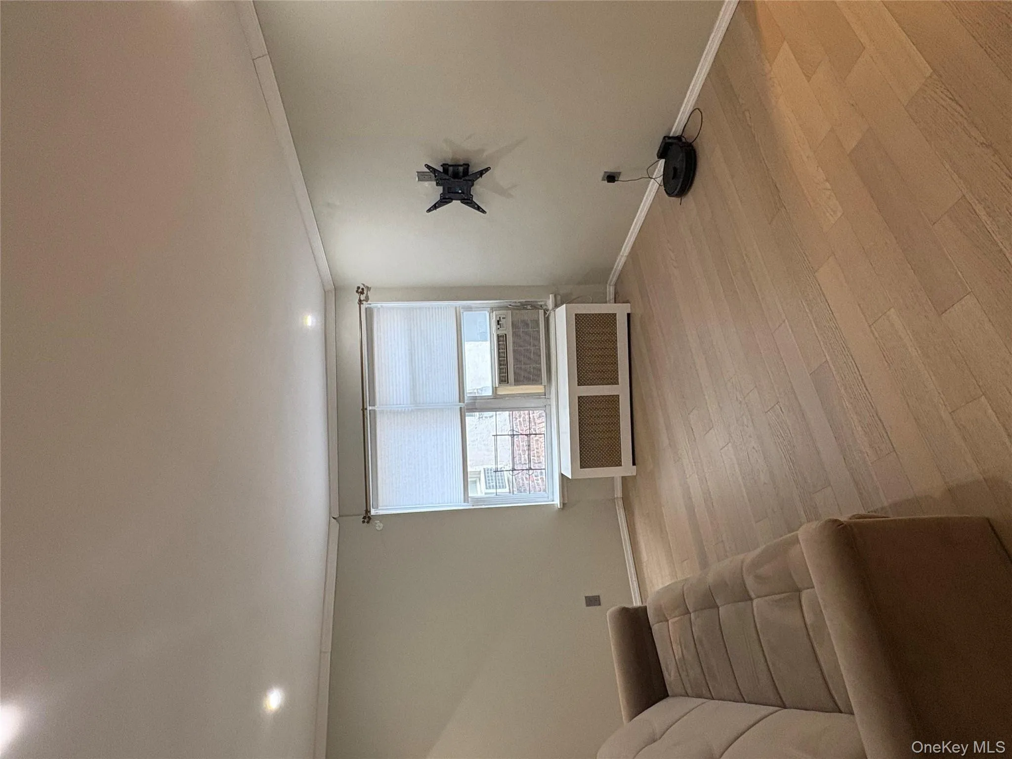 Sitting room featuring light wood-style floors, radiator, ornamental molding, recessed lighting, and cooling unit Sitting room featuring light wood-style floors, radiator, ornamental molding, recessed lighting, and cooling unit