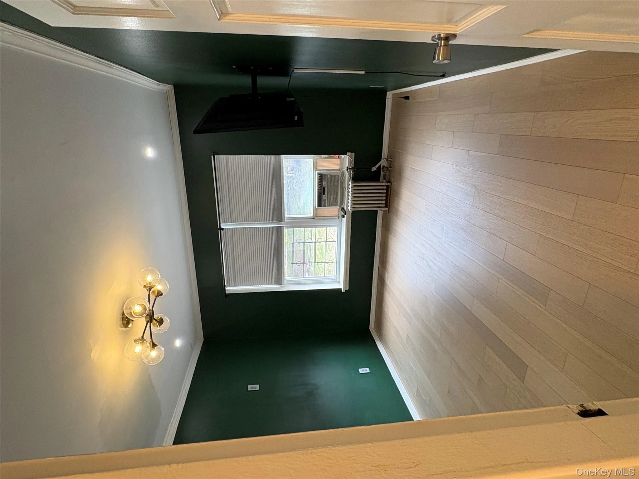Unfurnished room featuring ornamental molding, light wood-style flooring, radiator heating unit, and cooling unit Unfurnished room featuring ornamental molding, light wood-style flooring, radiator heating unit, and cooling unit
