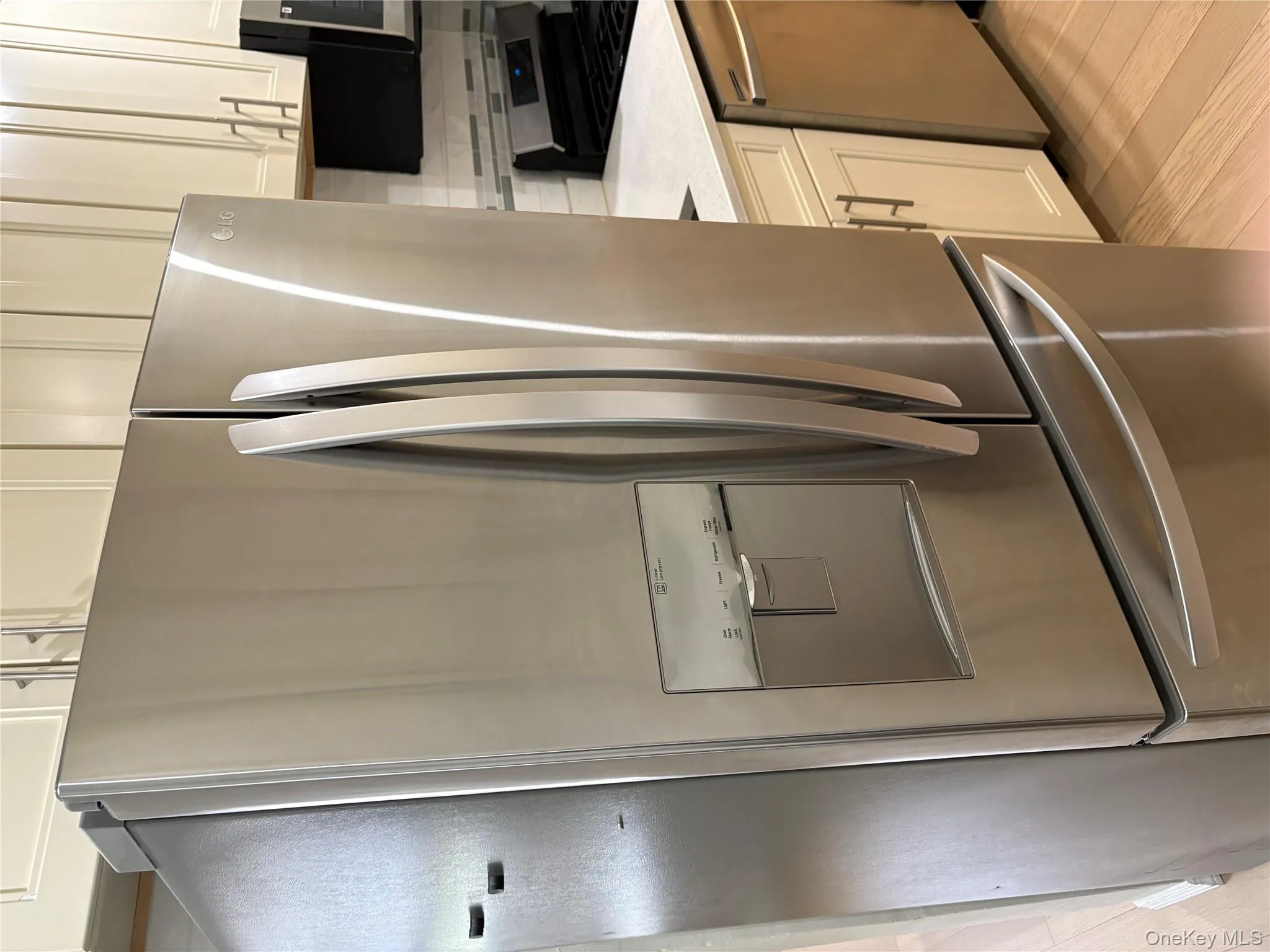 Kitchen featuring stainless steel appliances, light stone counters, and white cabinetry Kitchen featuring stainless steel appliances, light stone counters, and white cabinetry