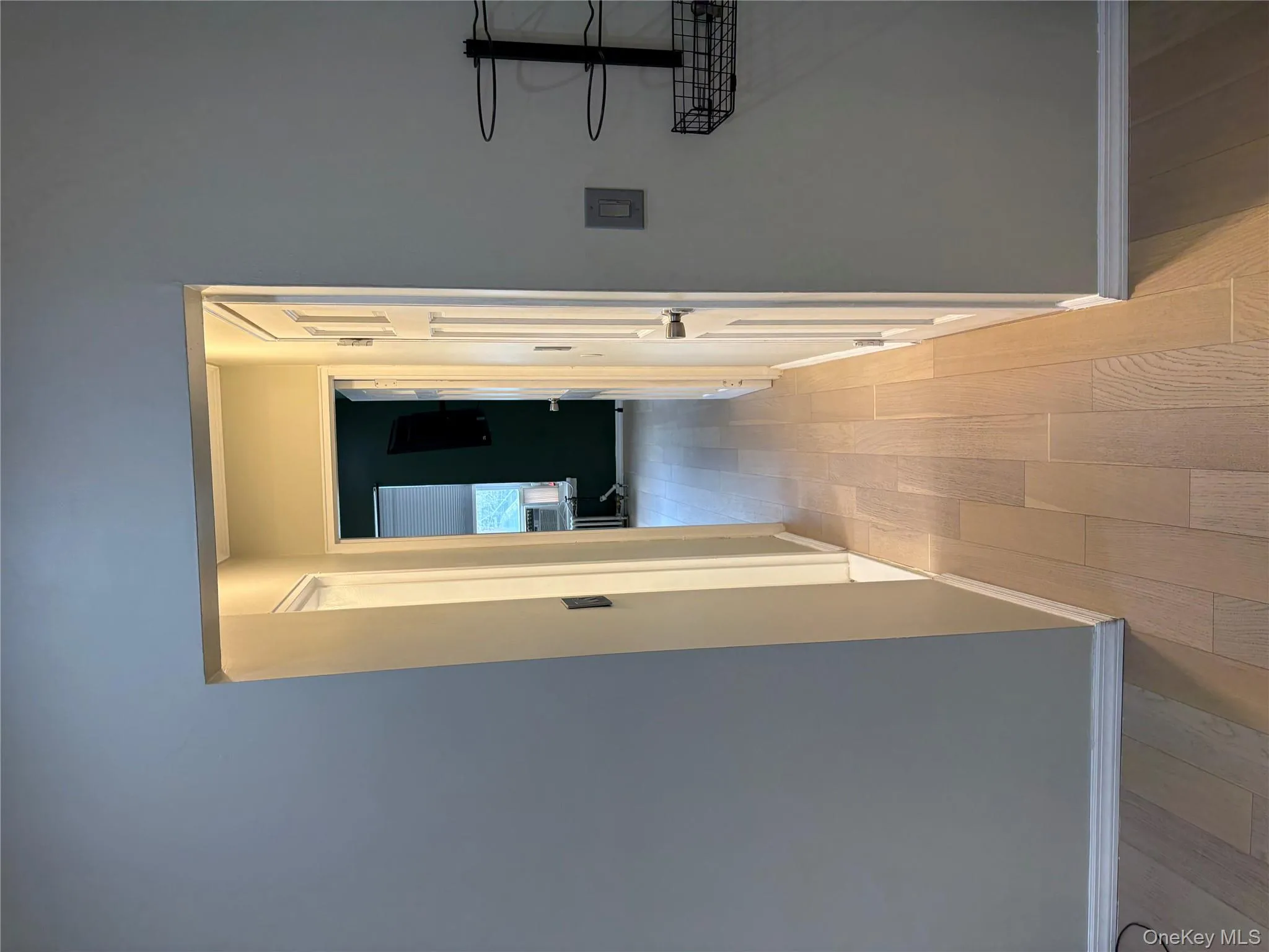 Hallway featuring baseboards and light wood-style floors Hallway featuring baseboards and light wood-style floors