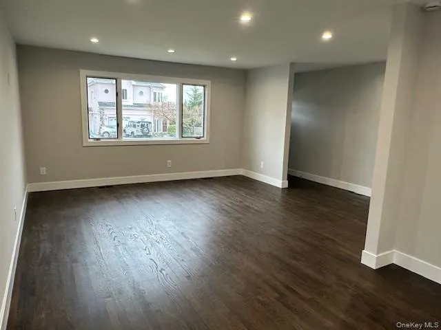 Living room featuring dark wood-type flooring and recessed lighting Living room featuring dark wood-type flooring and recessed lighting