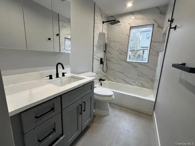 Bathroom featuring vanity and a combined bath / shower with marble appearance Bathroom featuring vanity and a combined bath / shower with marble appearance
