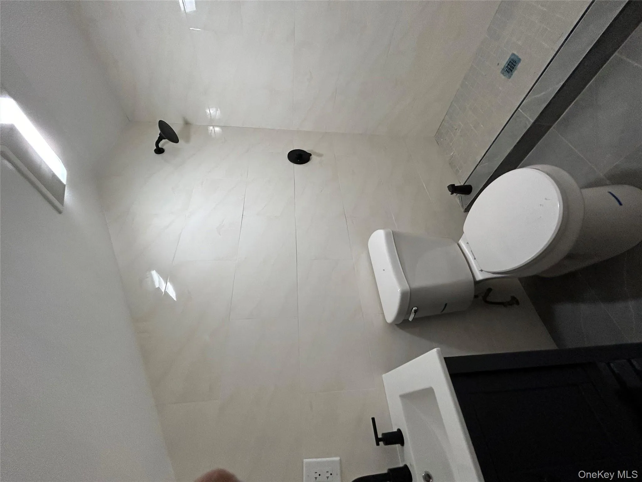 Bathroom with a stall shower, vanity, tile patterned flooring, and tile walls Bathroom with a stall shower, vanity, tile patterned flooring, and tile walls