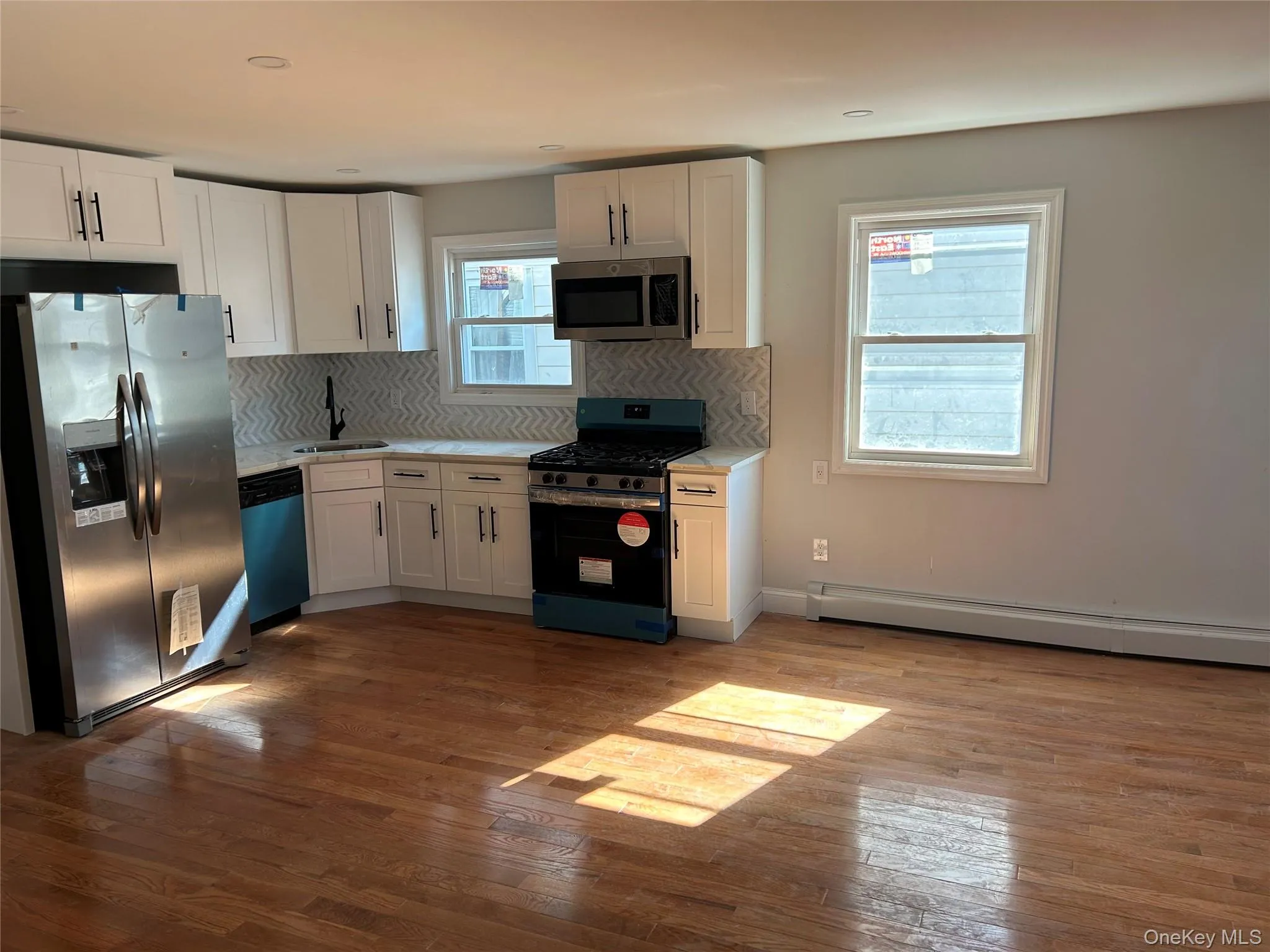 Kitchen featuring stainless steel appliances, white cabinetry, light countertops, and recessed lighting Kitchen featuring stainless steel appliances, white cabinetry, light countertops, and recessed lighting