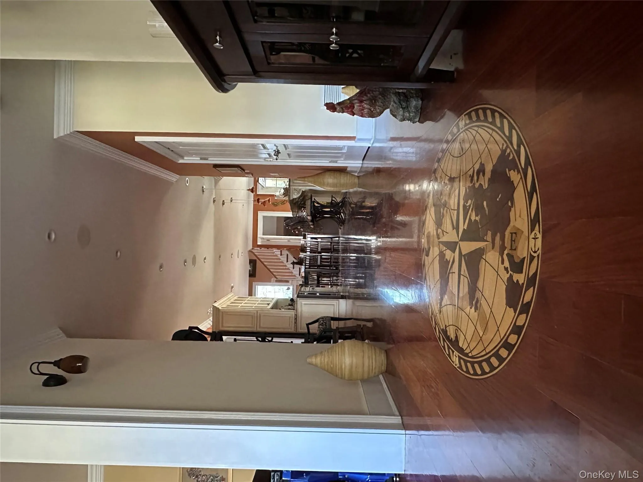 Red Brazilian Mahogany wide plank wood floors with custom compass insignia at entry Red Brazilian Mahogany wide plank wood floors with custom compass insignia at entry