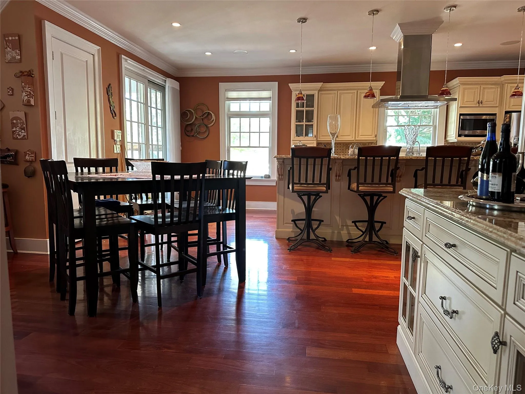 Eat-in-kitchen featuring continuous Red Brazilian Mahogony wide plank wood floors, ornamental molding, and recessed lighting Eat-in-kitchen featuring continuous Red Brazilian Mahogony wide plank wood floors, ornamental molding, and recessed lighting