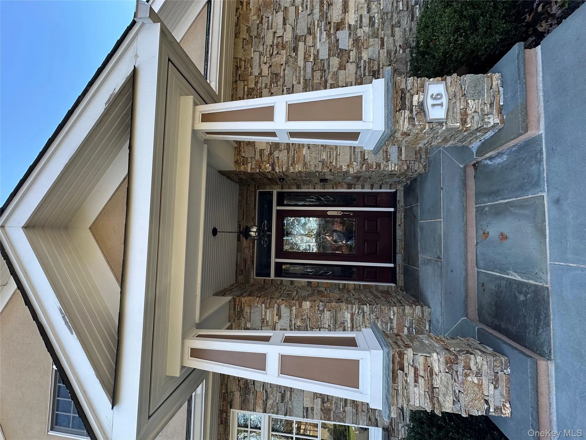 Doorway to property with covered porch and stone siding Doorway to property with covered porch and stone siding